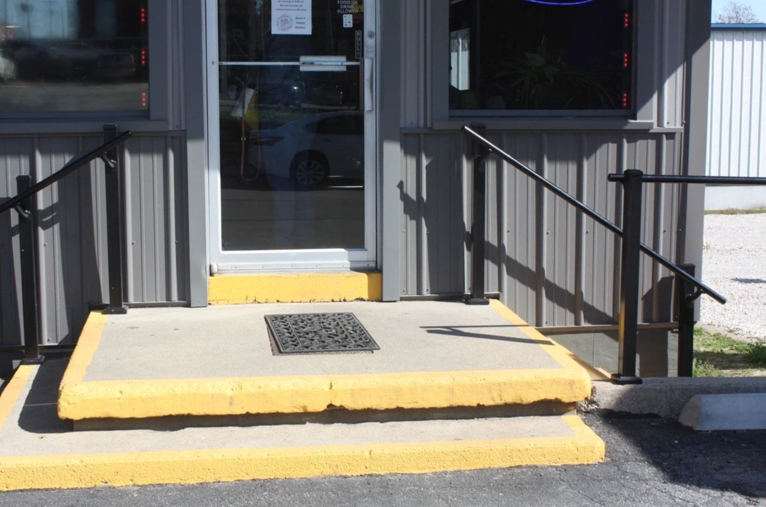 A gray building with yellow steps and a black railing