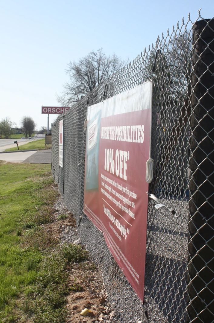 A chain link fence with a red sign on it