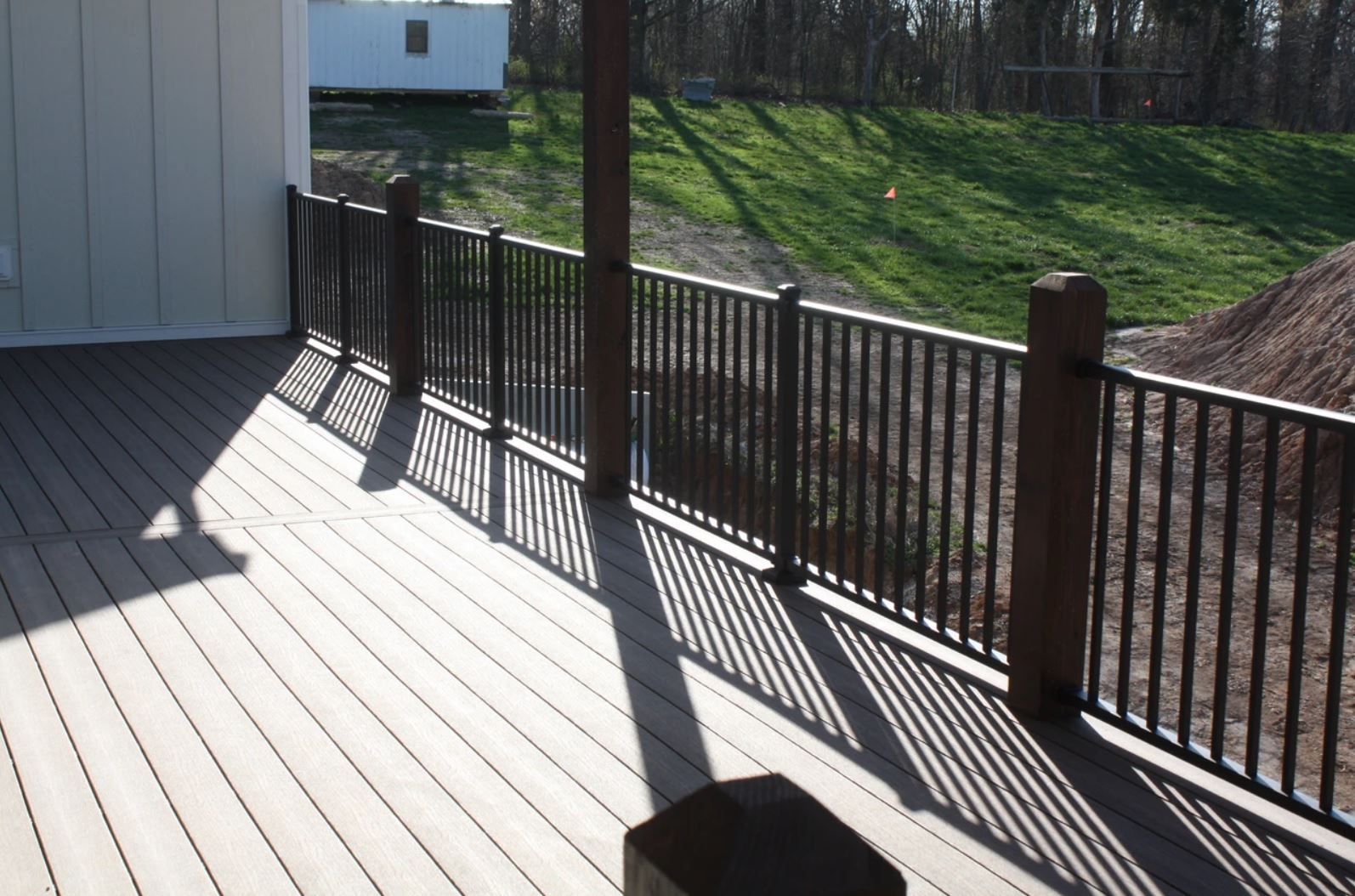 A wooden deck with a metal railing surrounding it