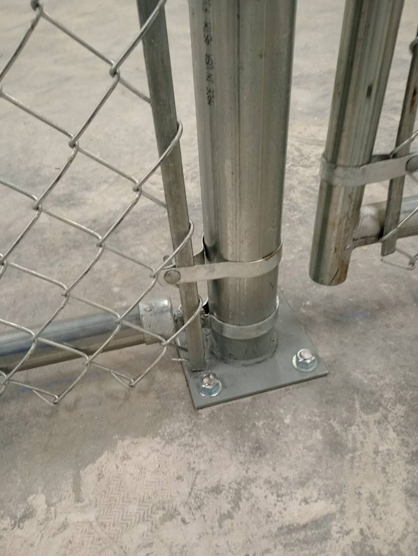 A chain link fence on top of a concrete floor