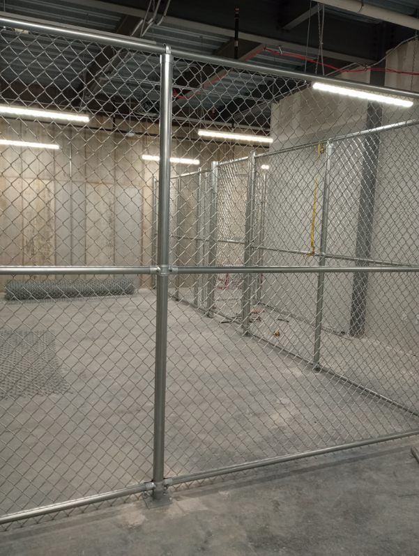 A chain link fence in an empty room