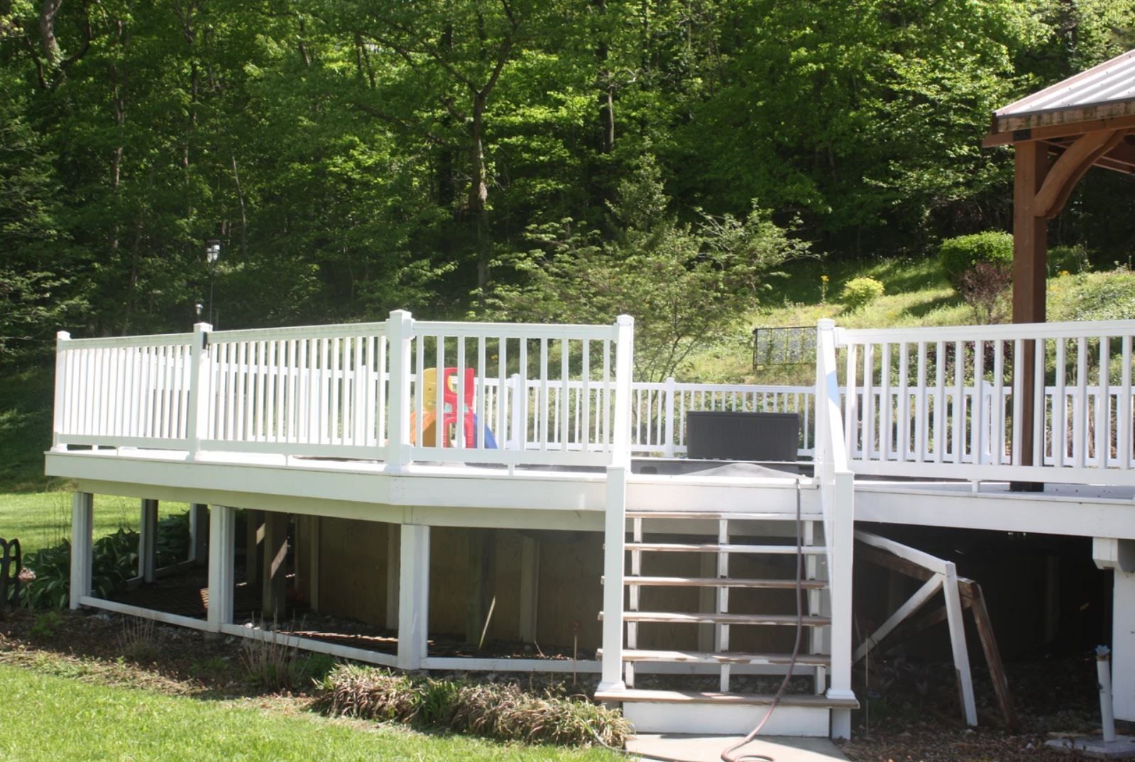 A large white deck with a gazebo in the background