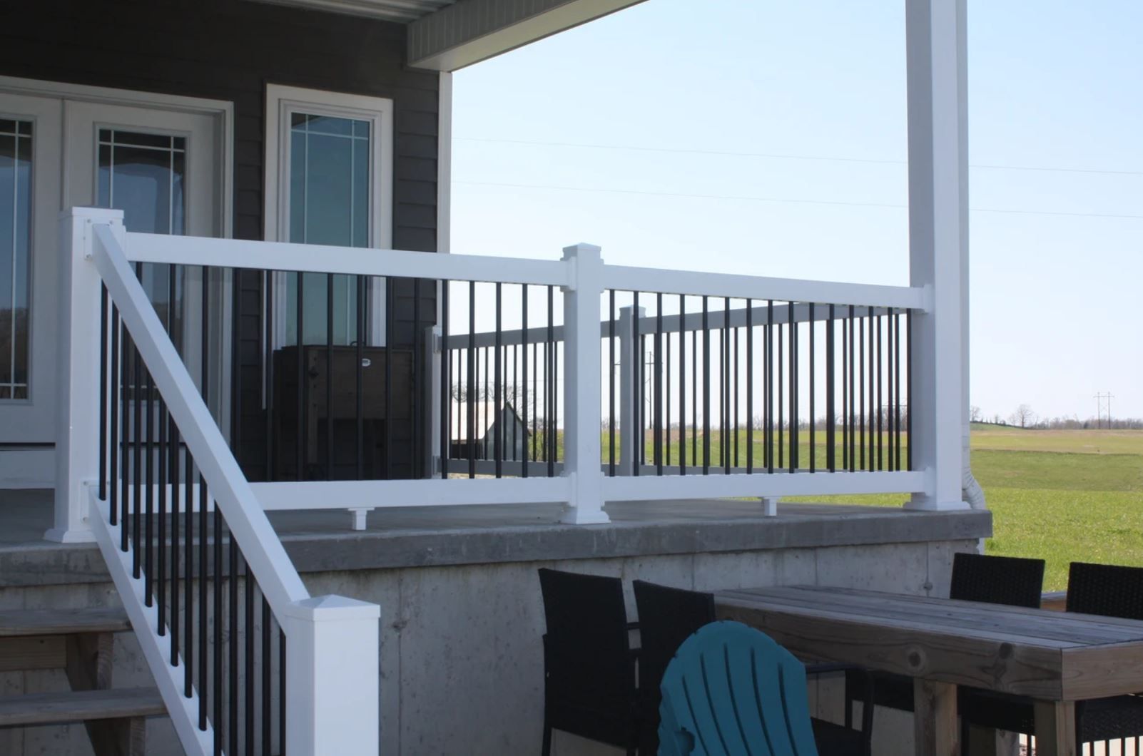A porch with a table and chairs and a white railing
