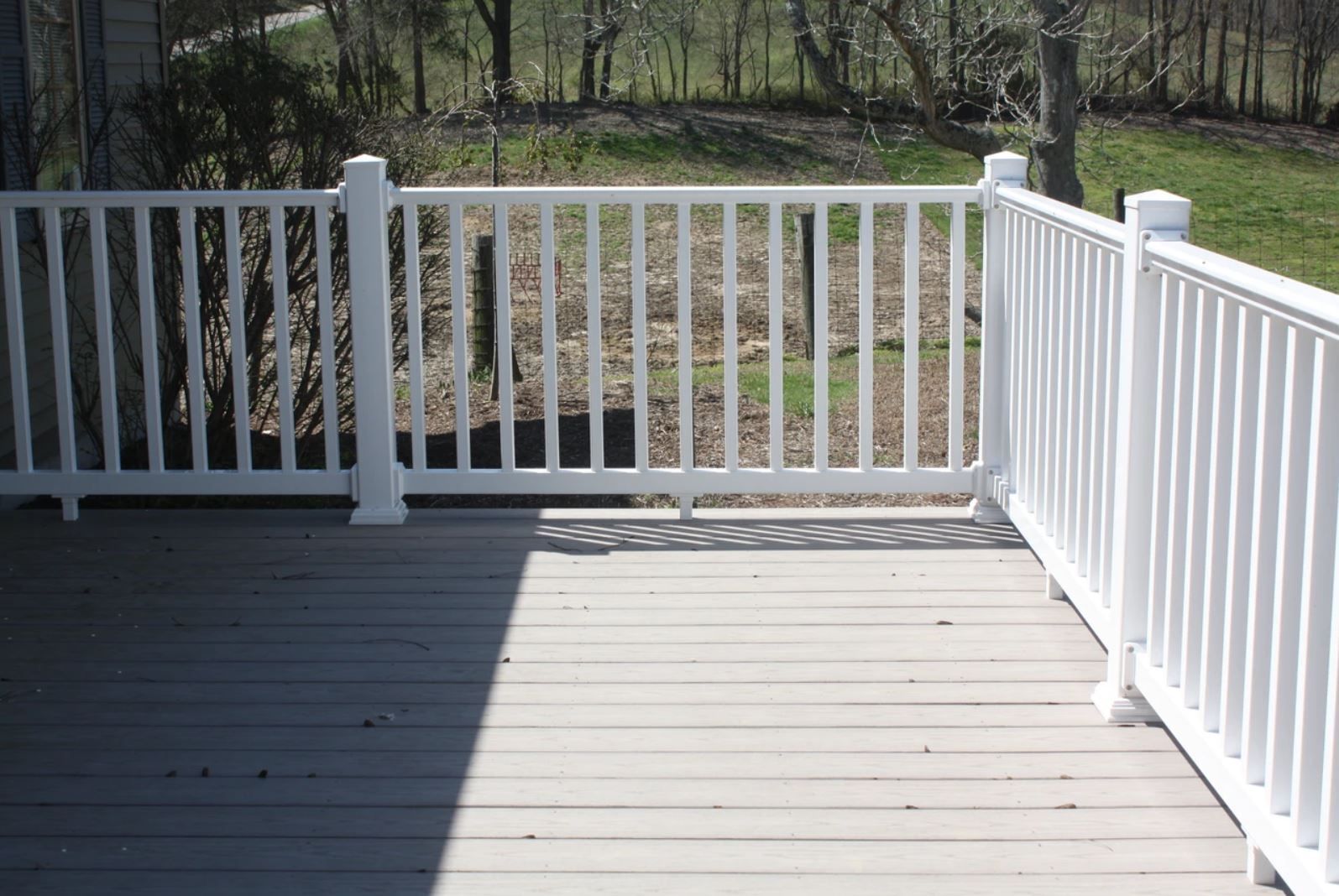 A deck with a white railing and a wooden floor.