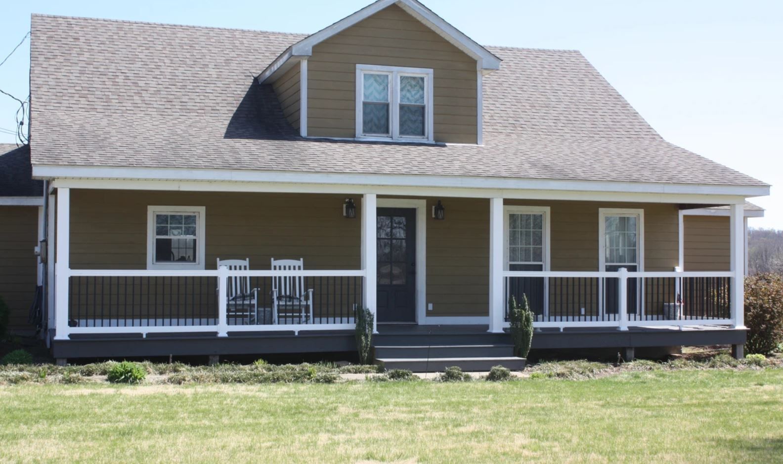 A house with a large porch and chairs on it