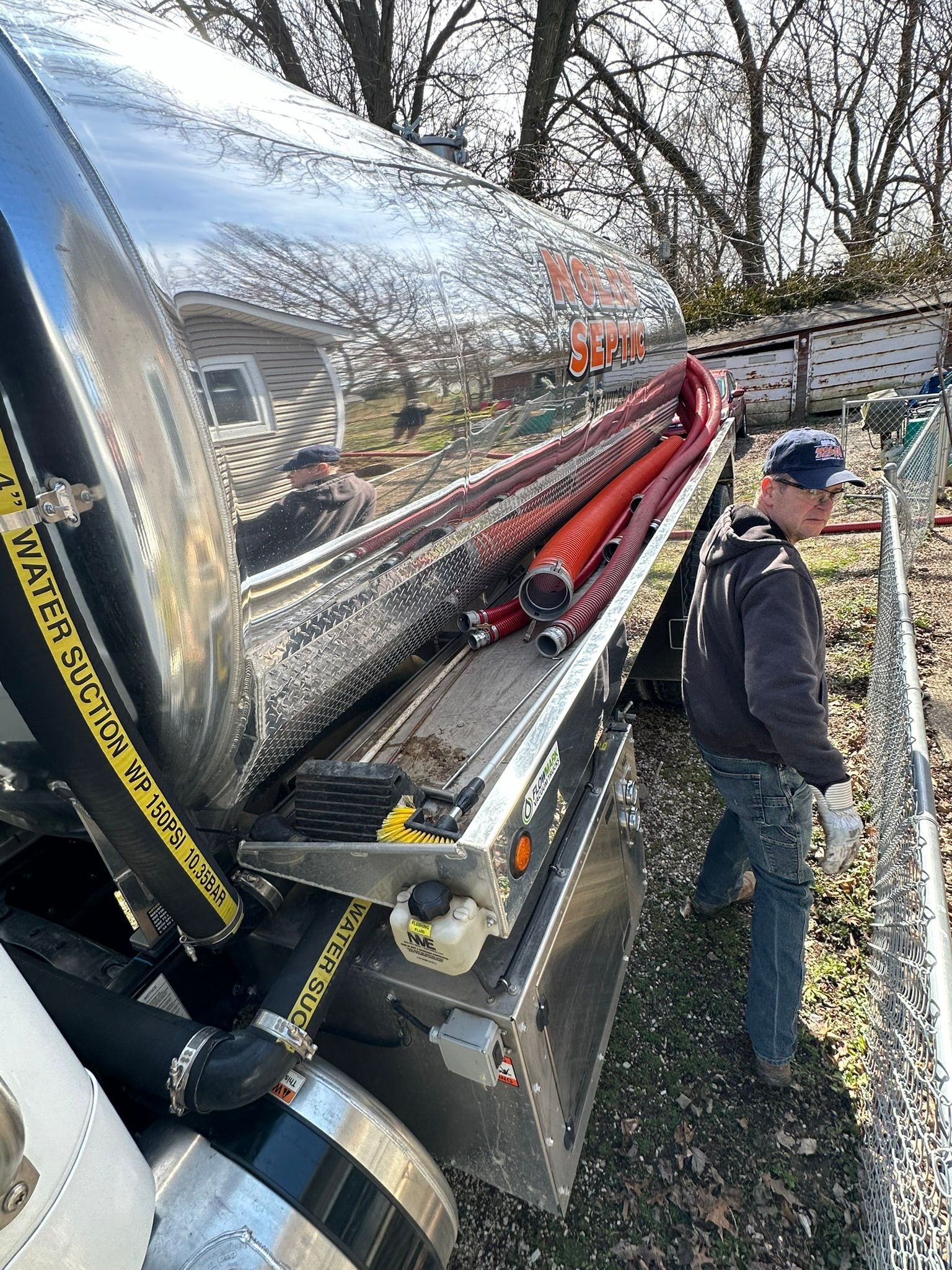 a man is standing next to a large tank on the back of a truck .