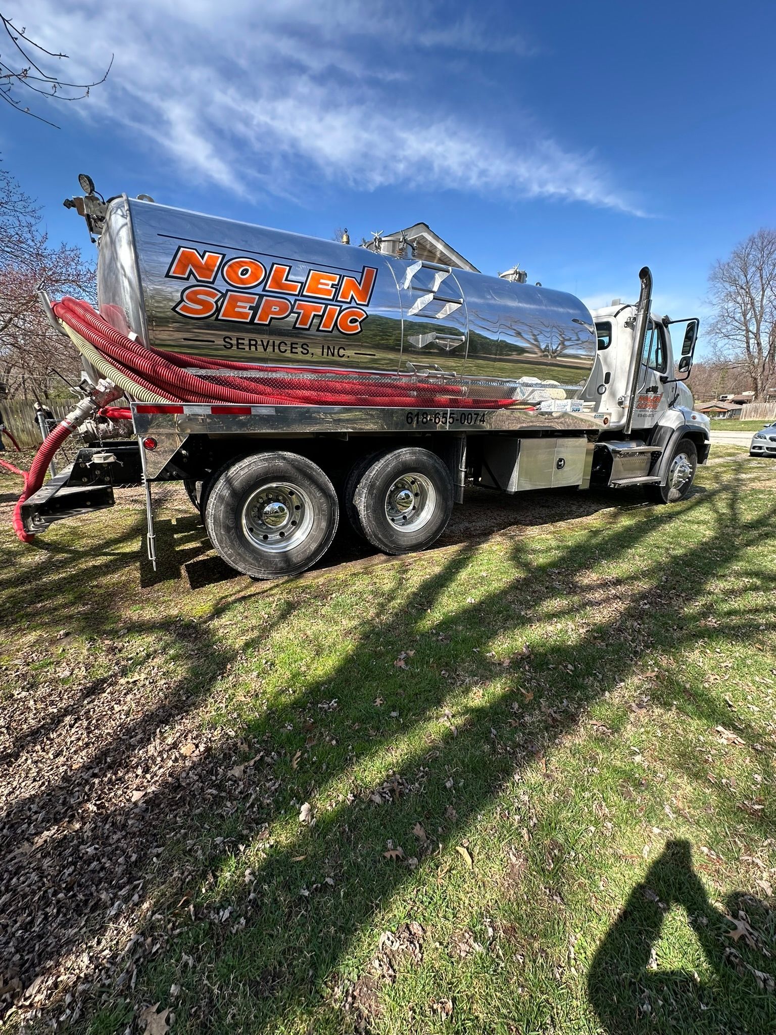 a large tanker truck is parked in a grassy field .