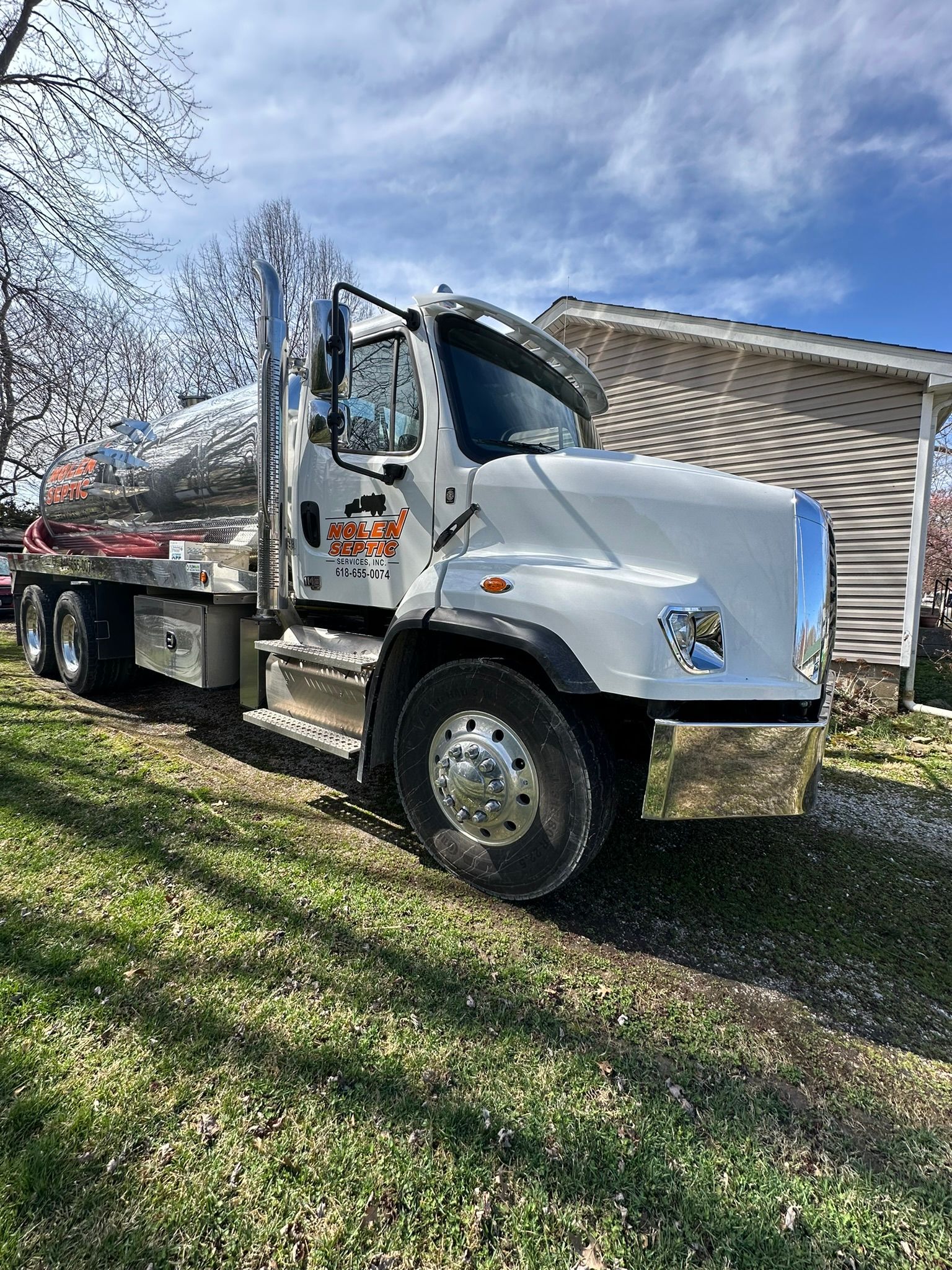 a white semi truck is parked in front of a house .
