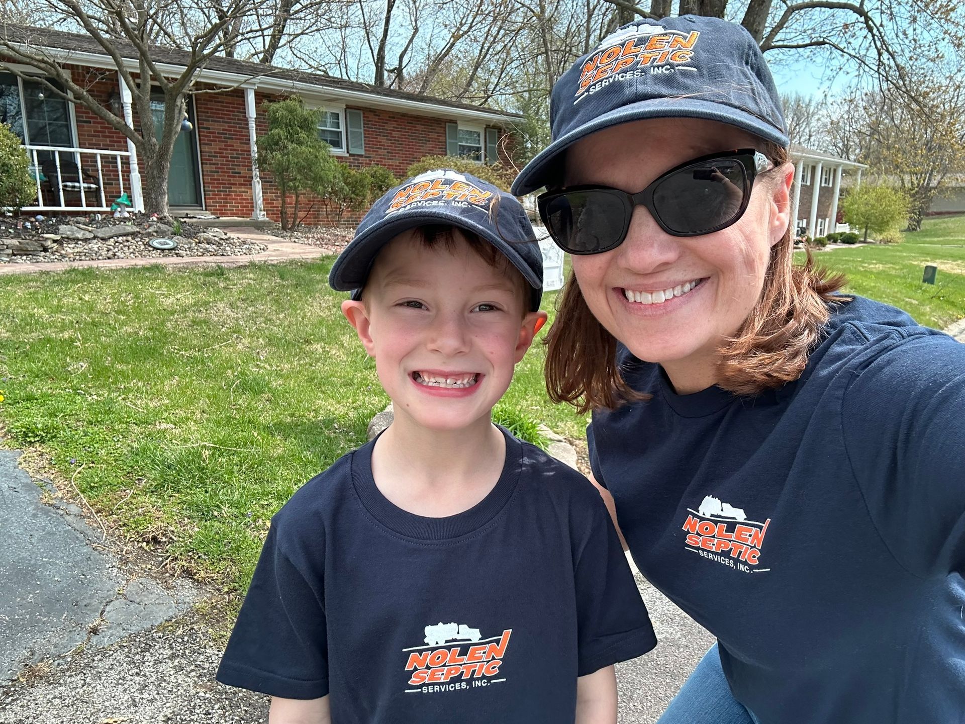 A woman and a boy wearing hats and sunglasses are posing for a picture.