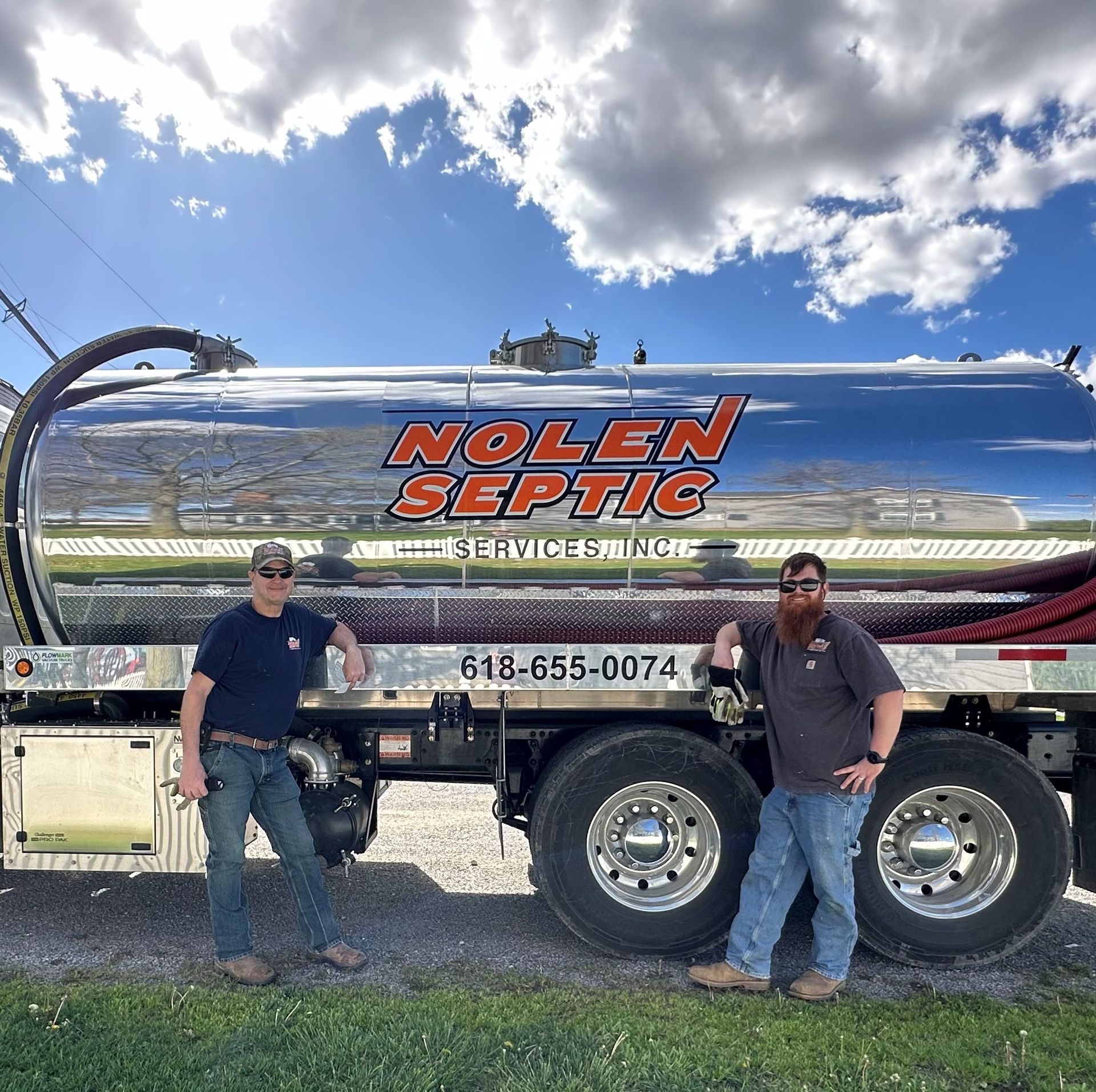 Two men are standing in front of a nolen septic truck