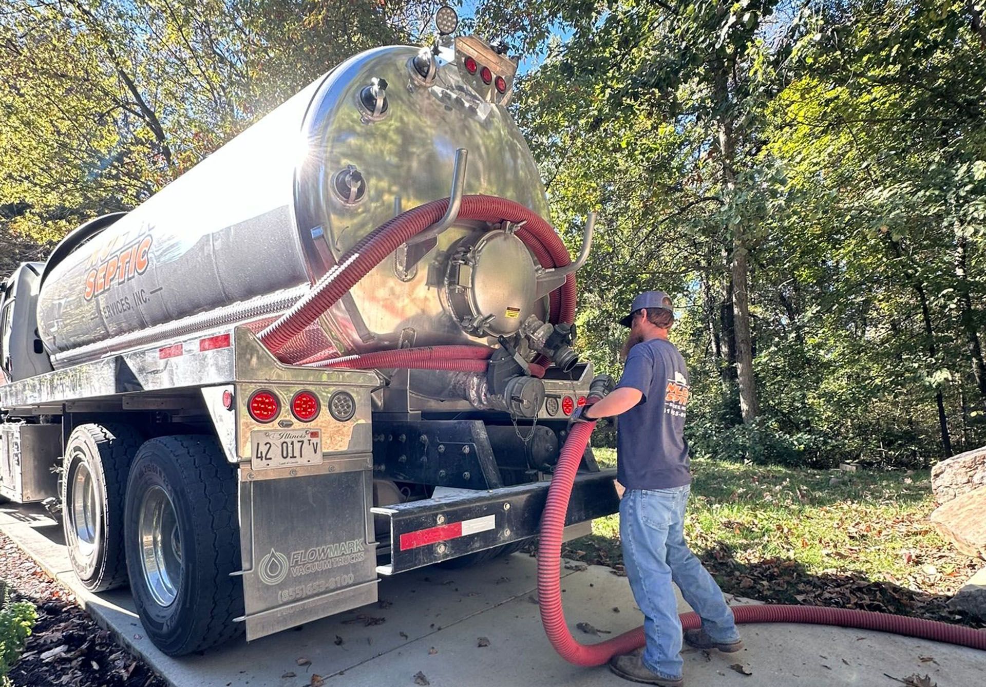 A man is pumping water from a vacuum truck.