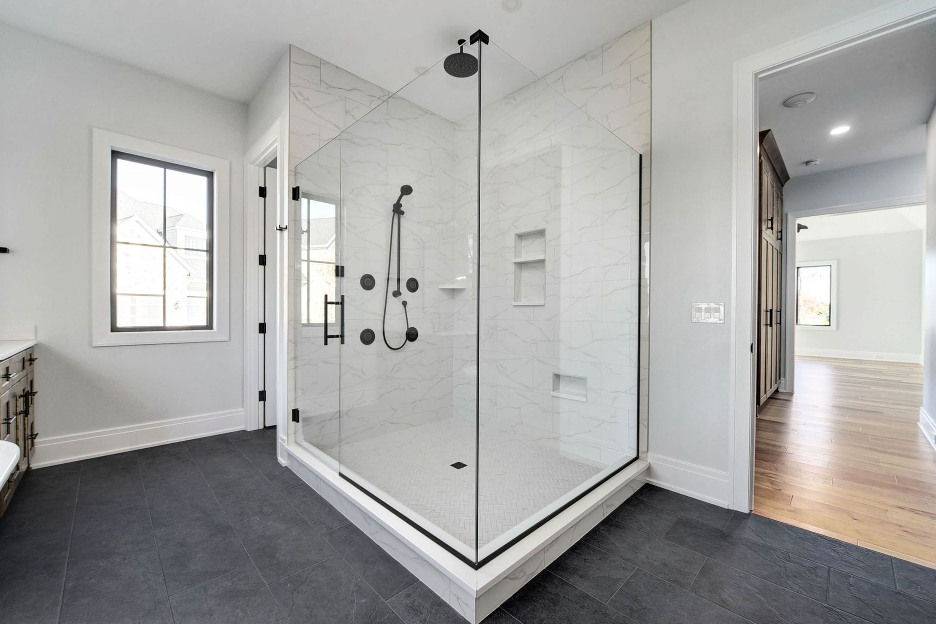 A bathroom with a walk in shower and a window.