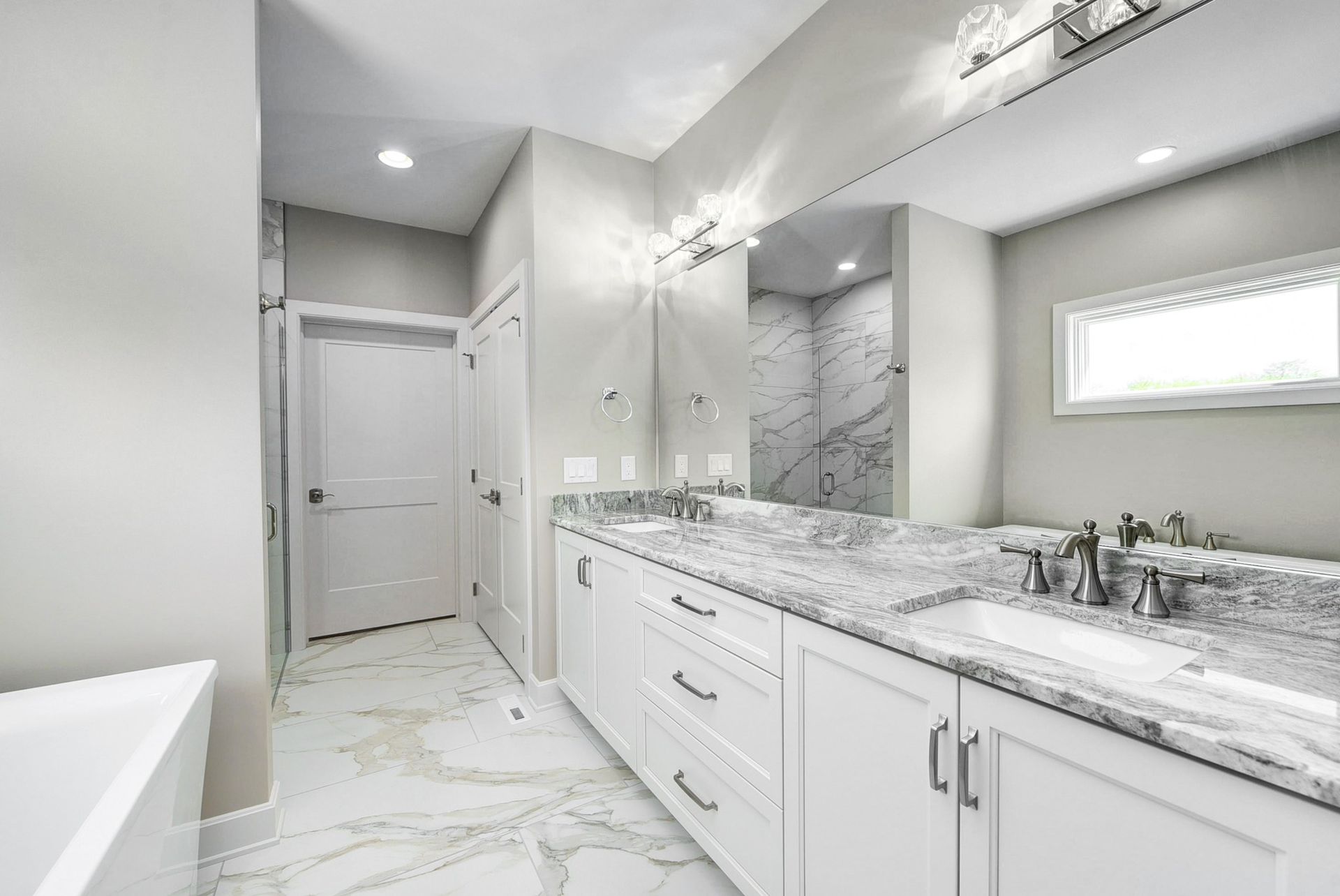 A bathroom with two sinks and a large mirror.