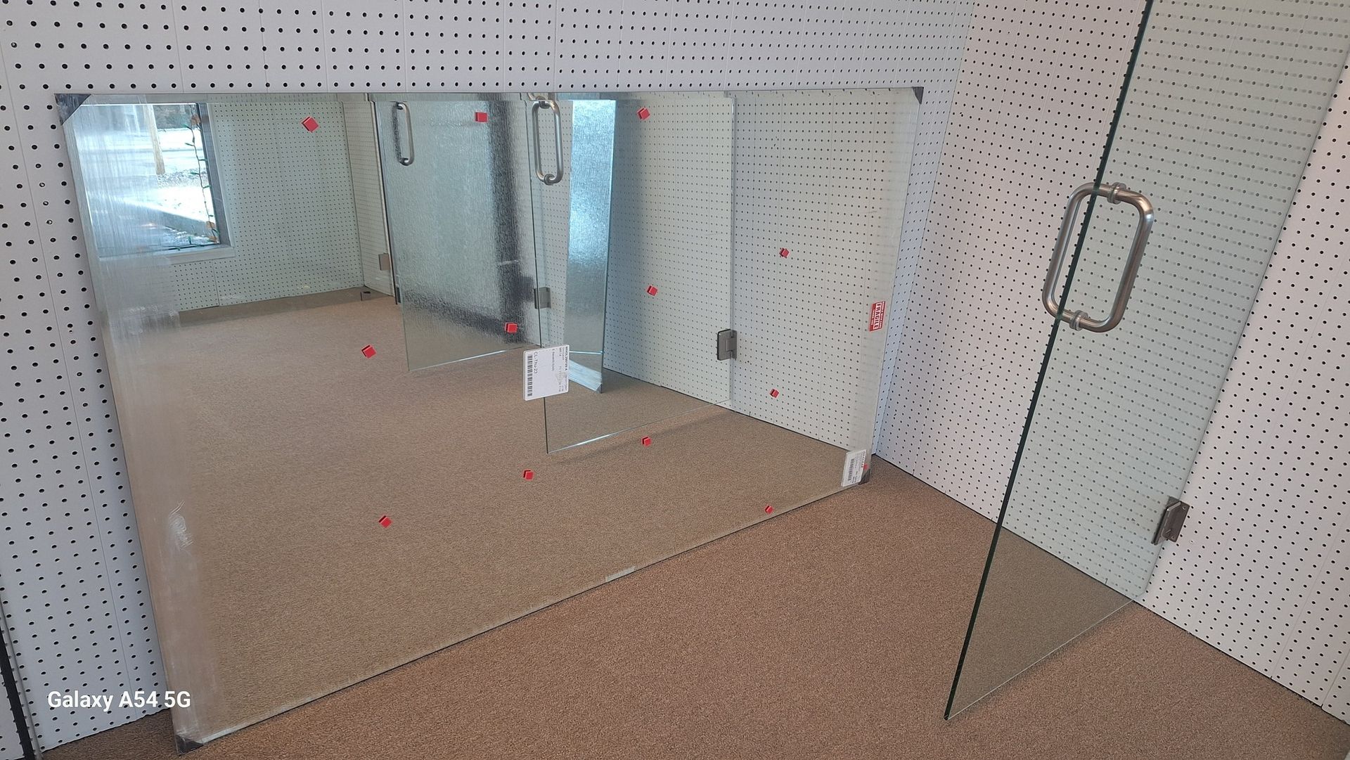 A room with a large mirror and a glass door