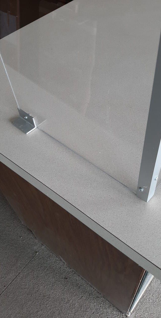 A white table with a clear acrylic divider on it.