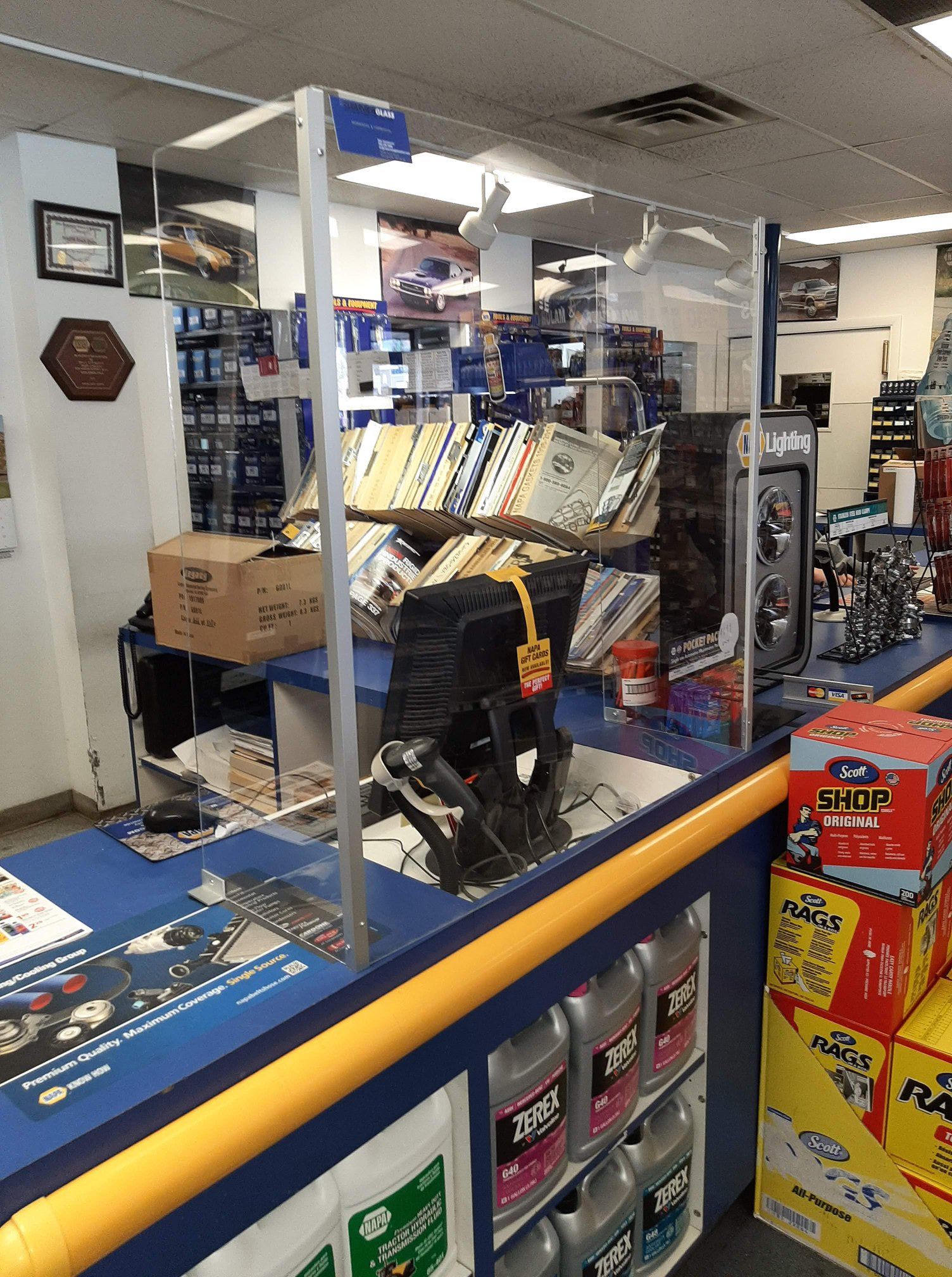 A counter in a car parts store with a glass barrier.