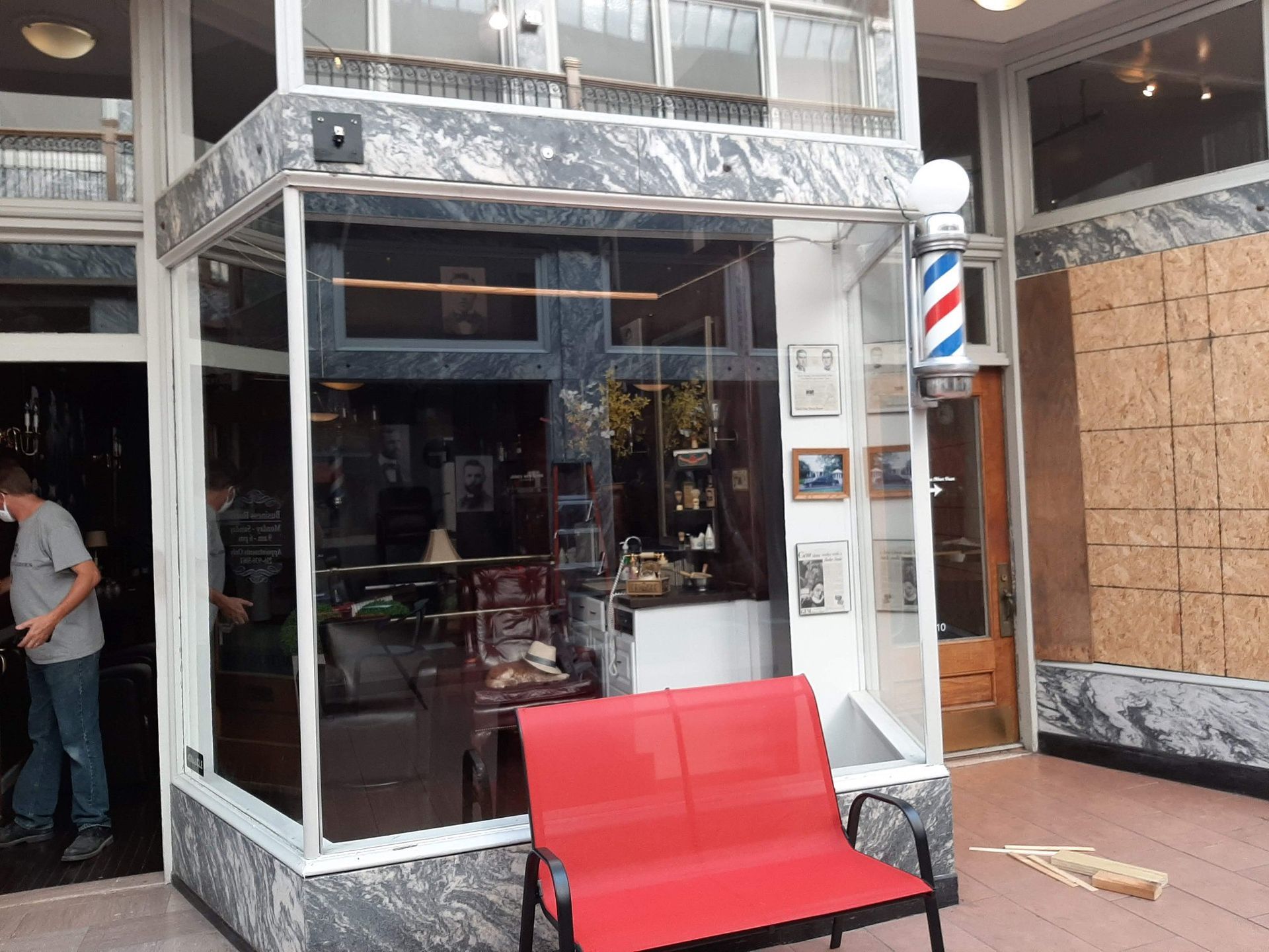 A barber shop with a red bench in front of it