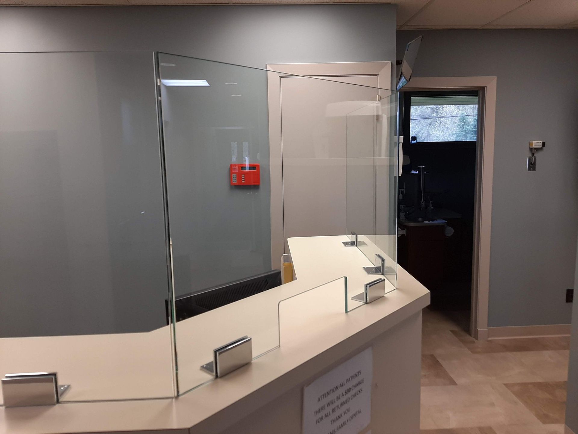 A glass barrier is sitting on a counter in a room.