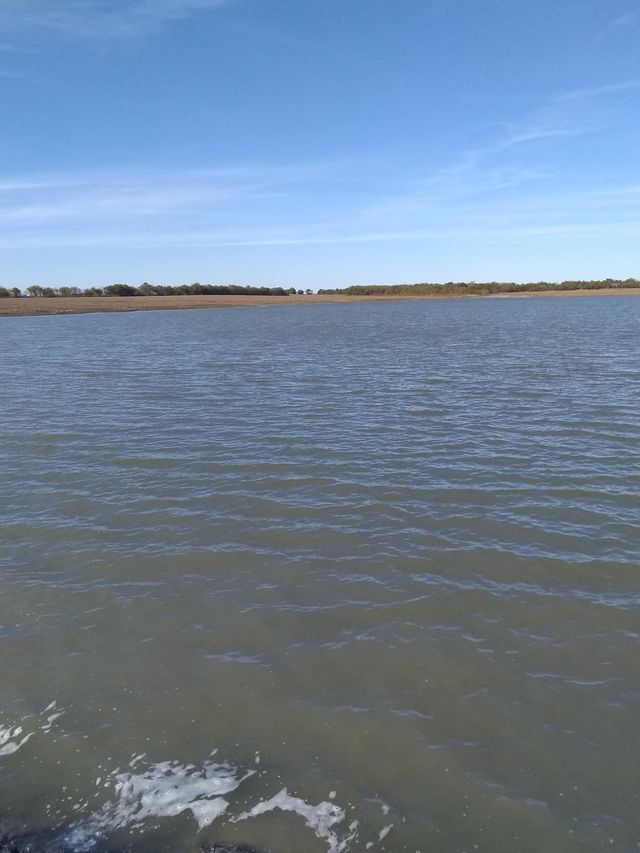 a large body of water with a blue sky in the background .