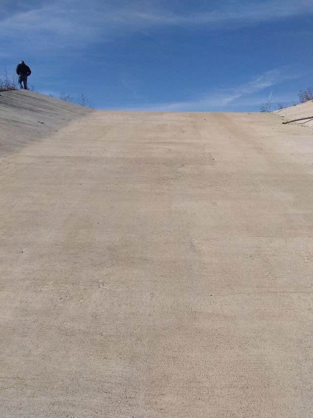 a person is standing on top of a sandy hill .