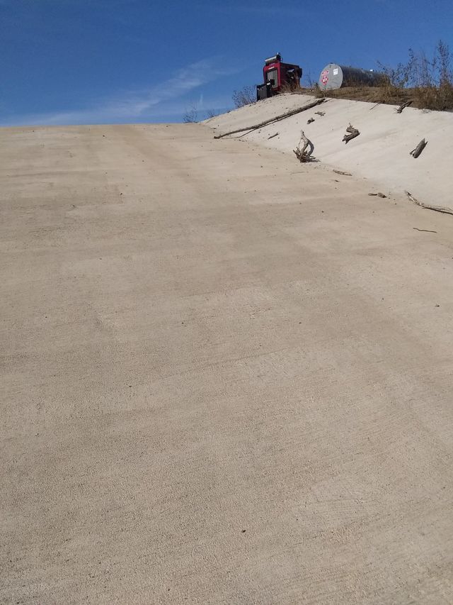 a truck is parked on top of a sandy hill .