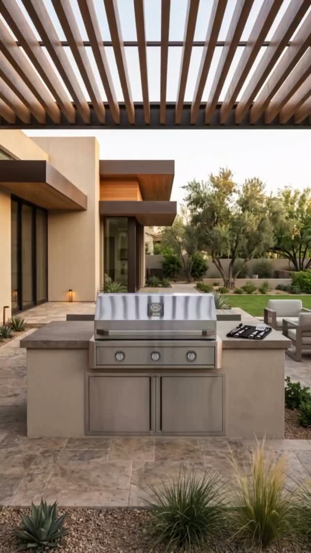 Modern outdoor patio with built-in stainless steel grill under a slatted pergola