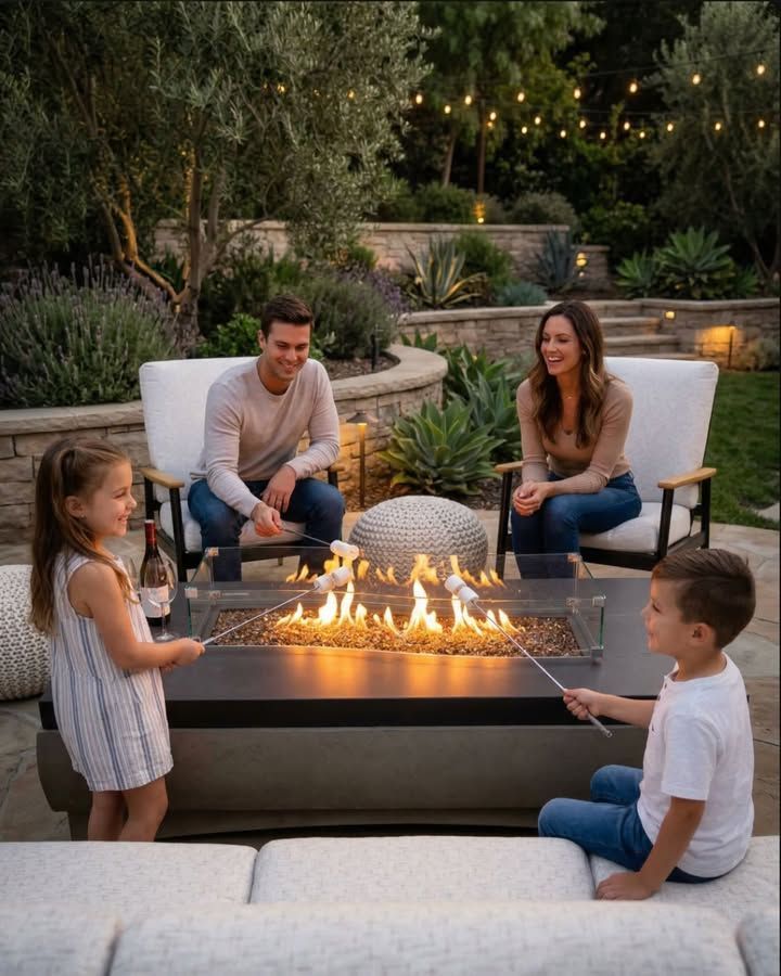 Family sitting around a fire pit in a landscaped backyard at dusk