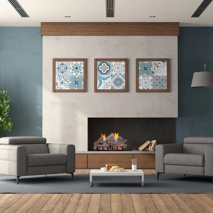 Modern living room with fireplace, gray sofas, and three framed wall art pieces above the mantel