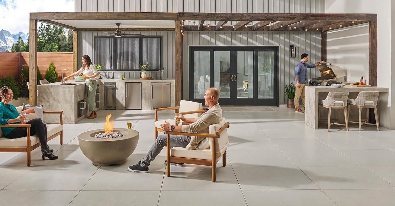 Modern patio lounge with fire pit, seating area, and outdoor kitchen under a pergola