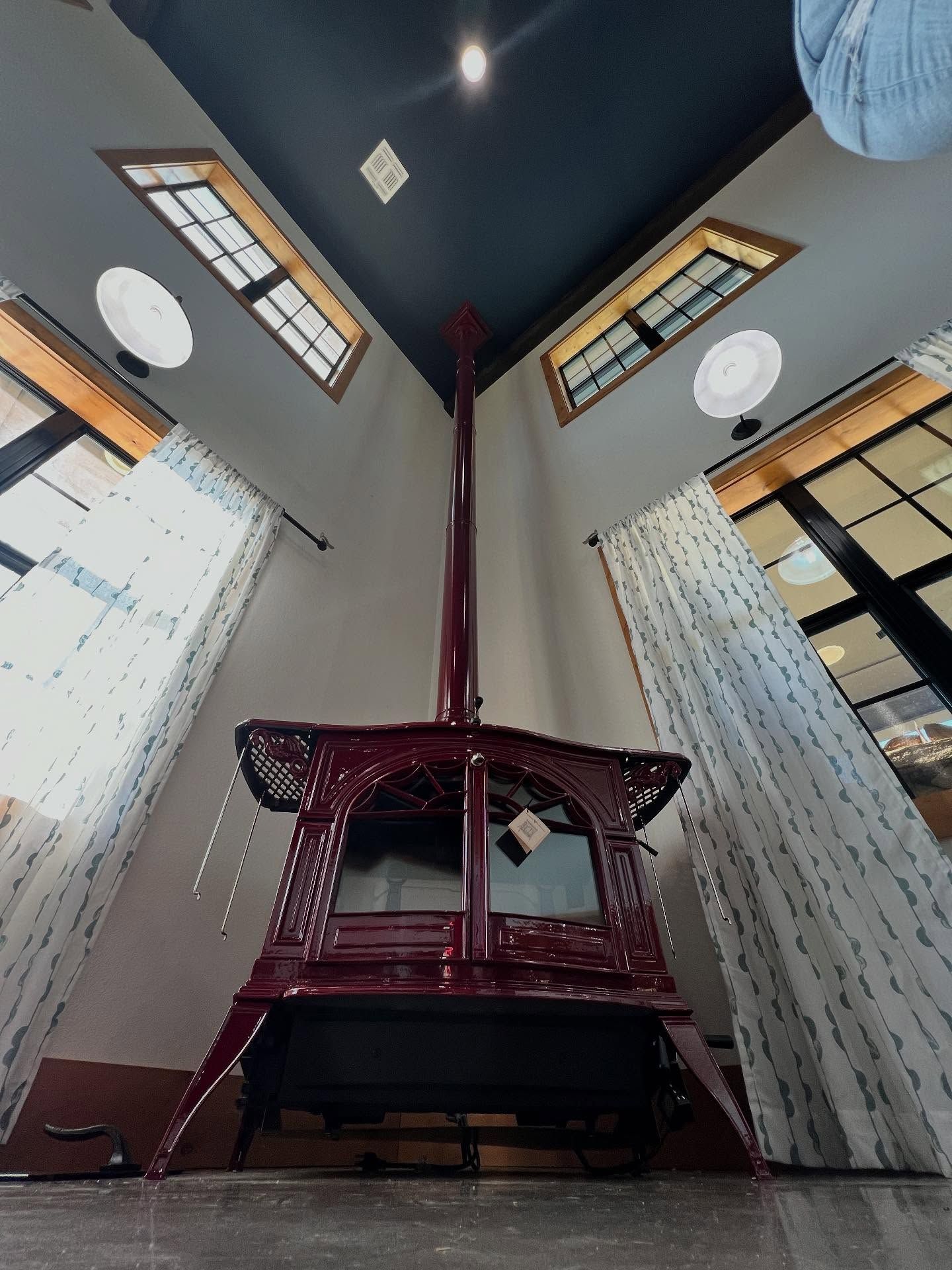 Small shrine altar in a high-ceilinged room with windows and hanging lights