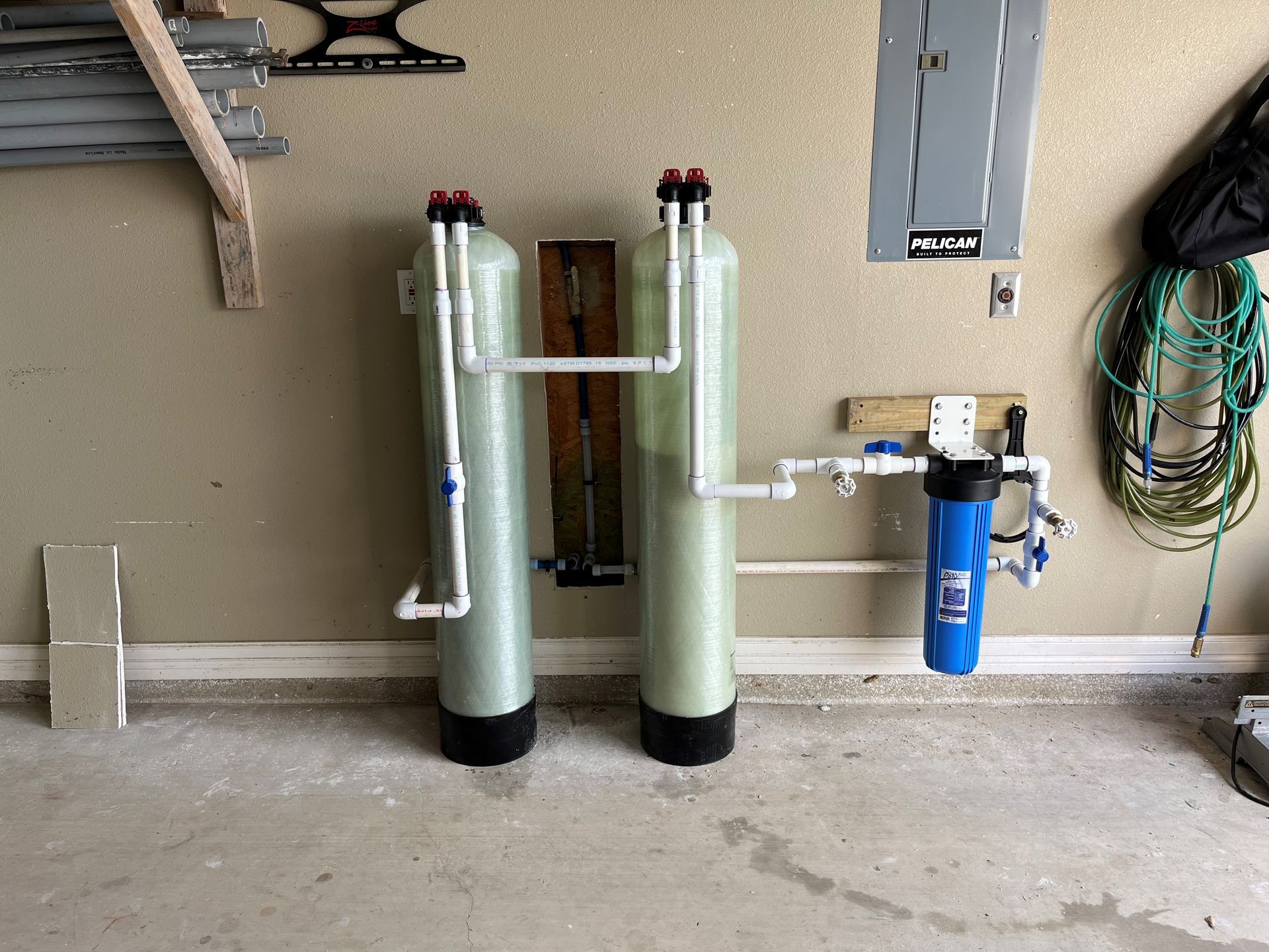 Two water filters are sitting next to each other in a garage.