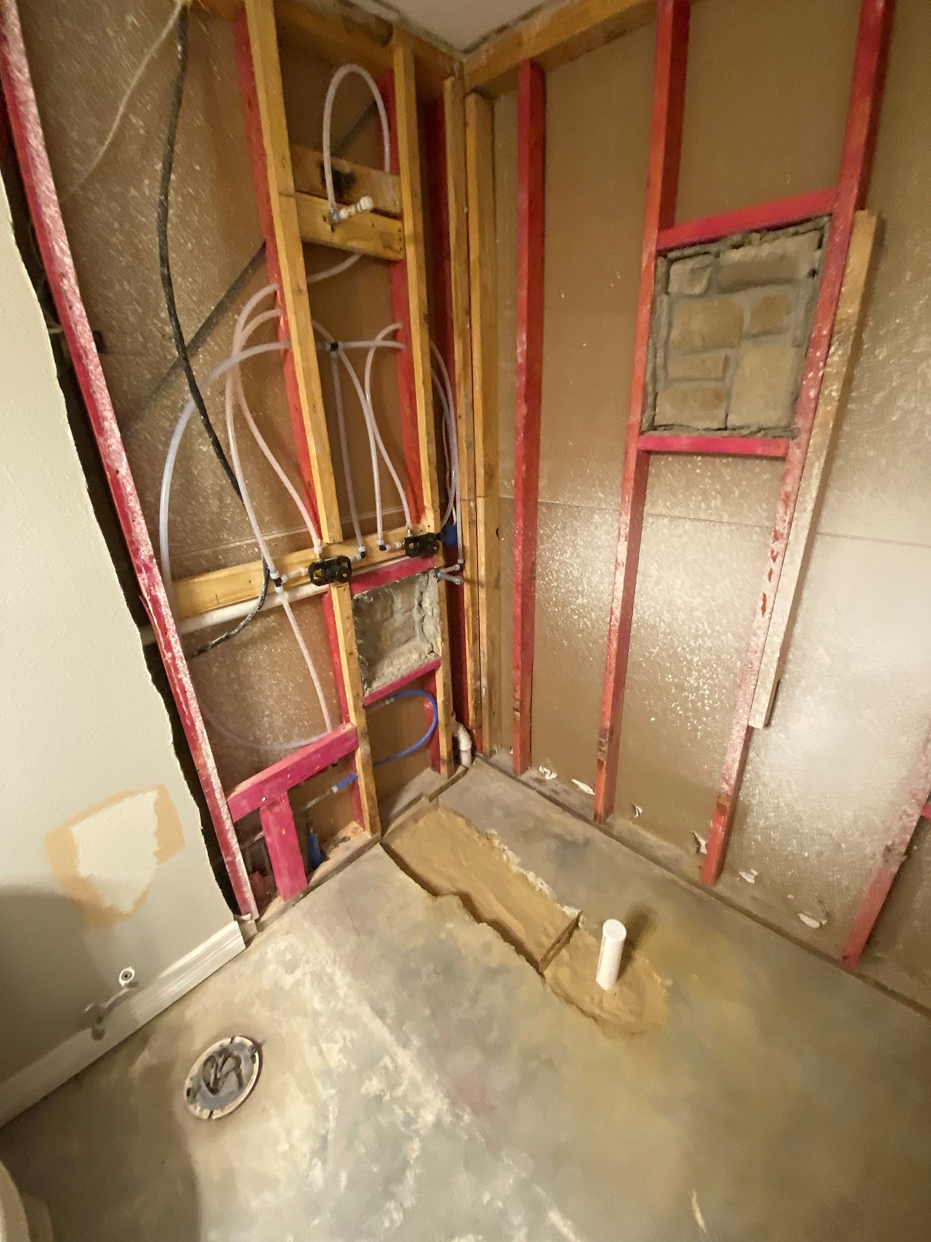 A bathroom under construction with wooden walls and a toilet.