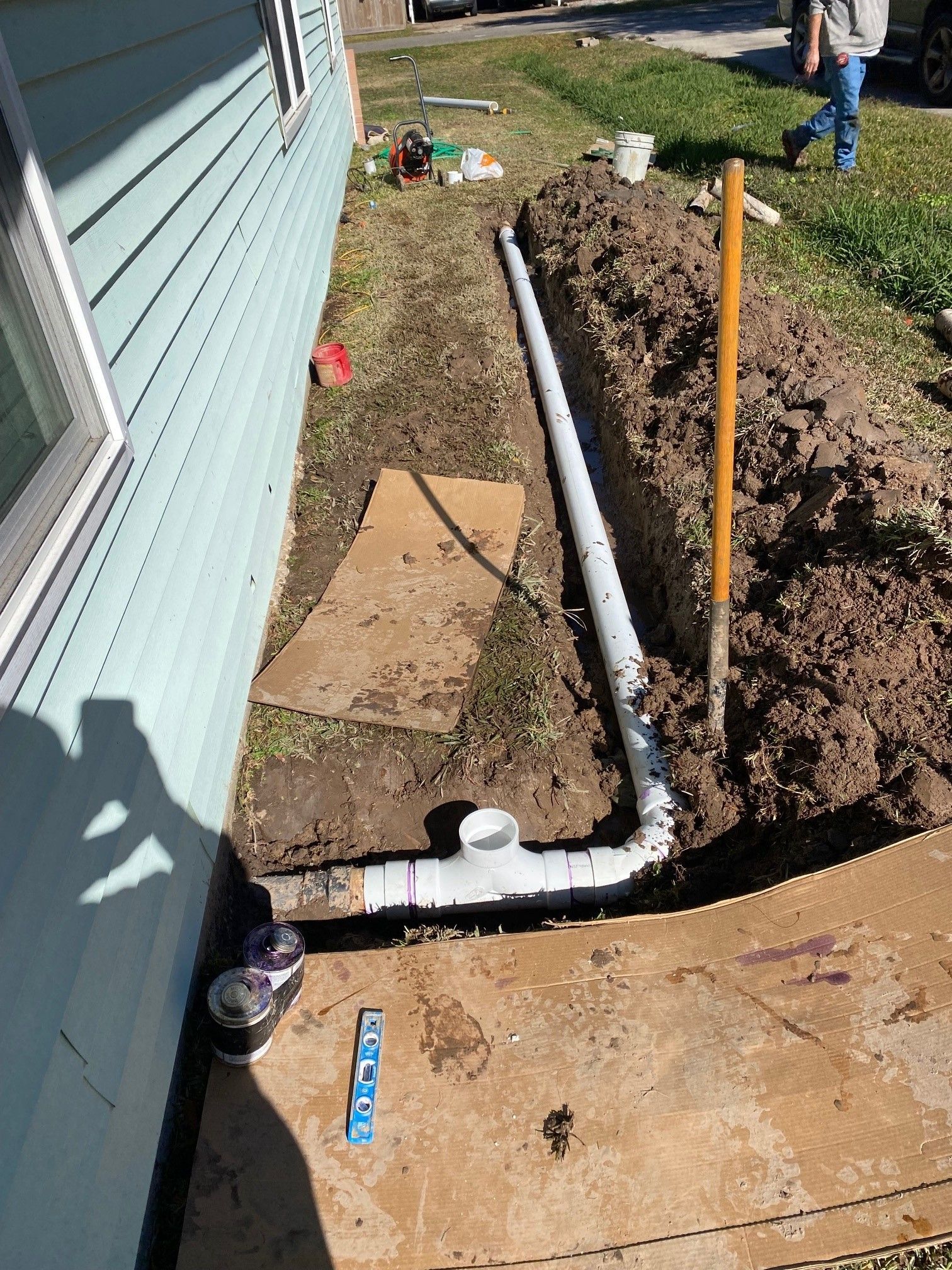 A drain pipe is being installed on the side of a house.