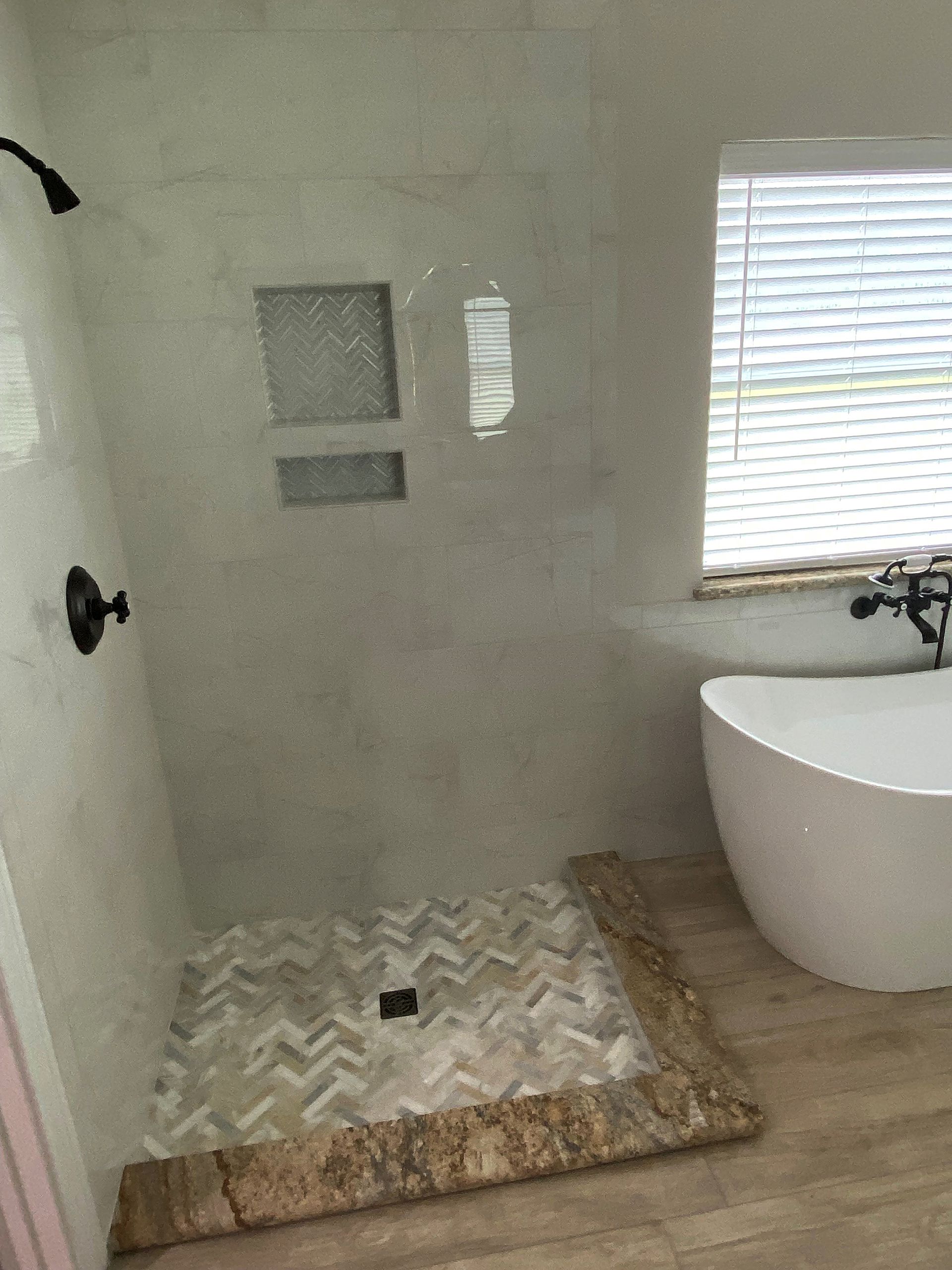 A bathroom with a tub , shower , and window.