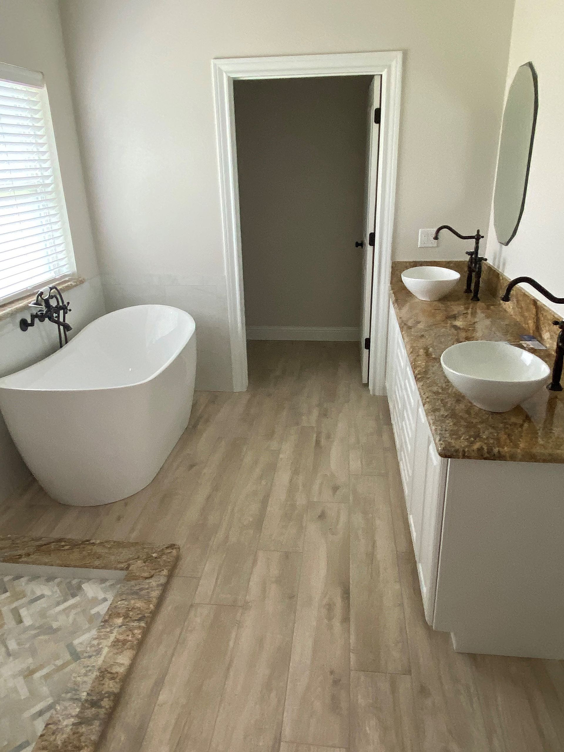 A bathroom with a bathtub , sinks , and a walk in shower.