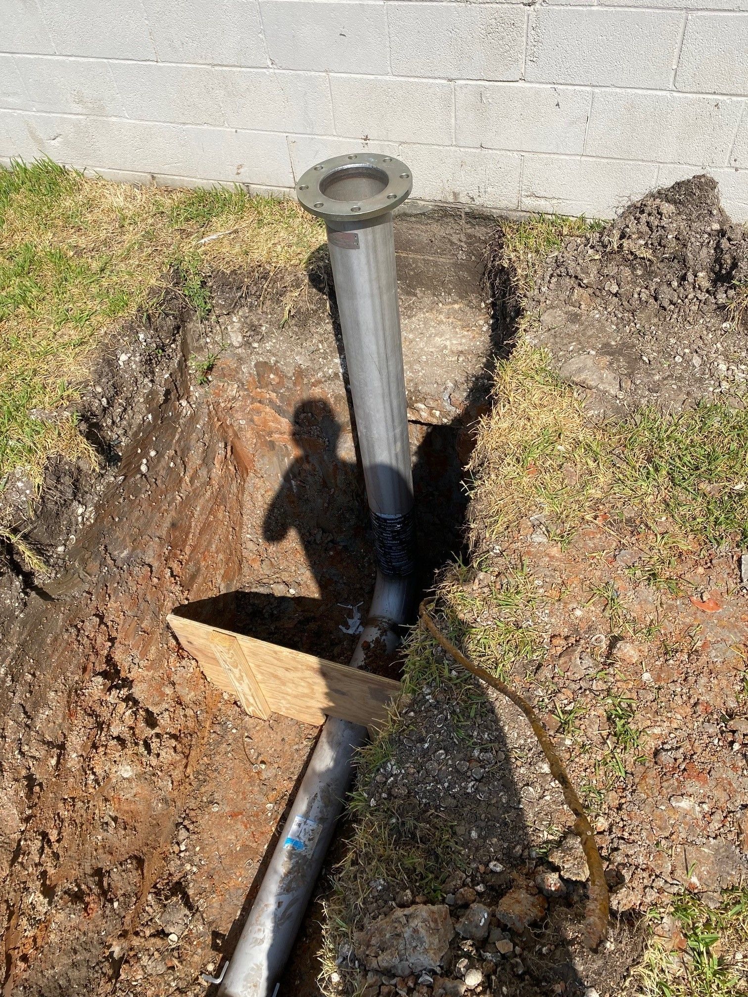 A pipe is being installed in a hole in the ground.