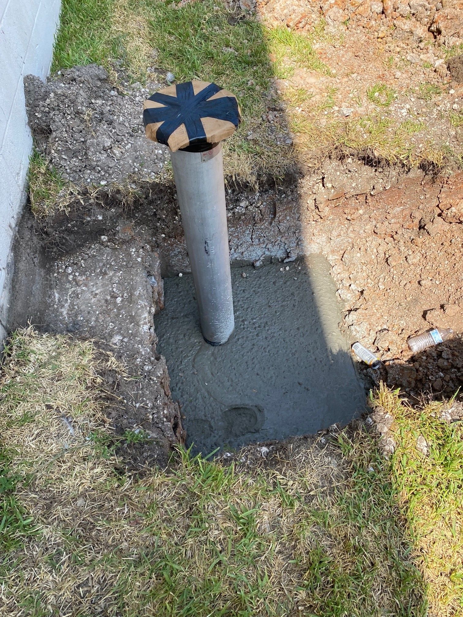 A pipe is sitting in the middle of a hole in the ground.
