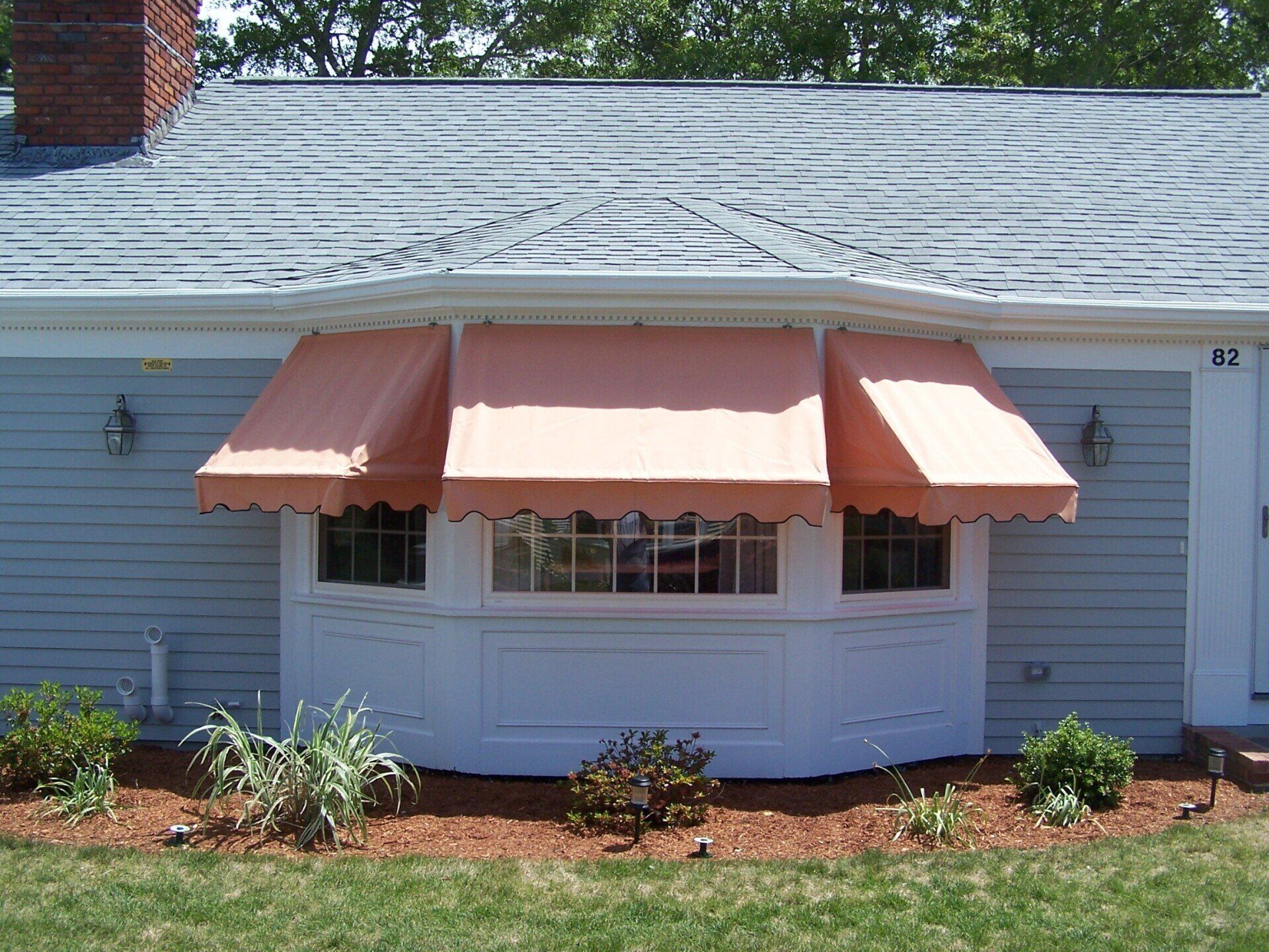 A house with a window with a pink awning on it