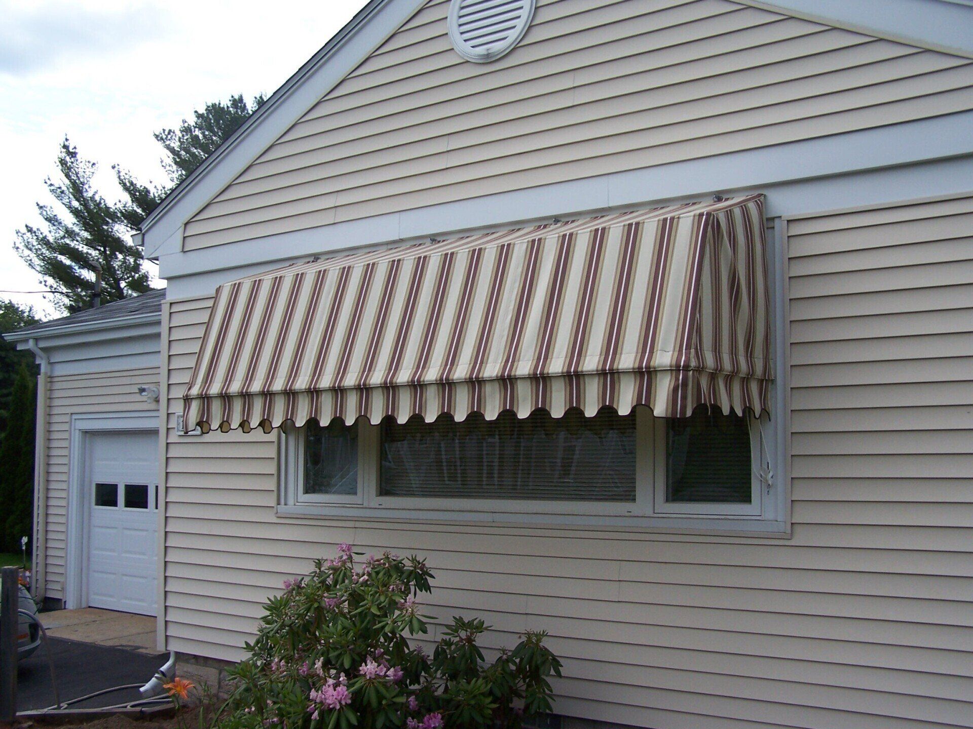 A house with a striped awning over a window