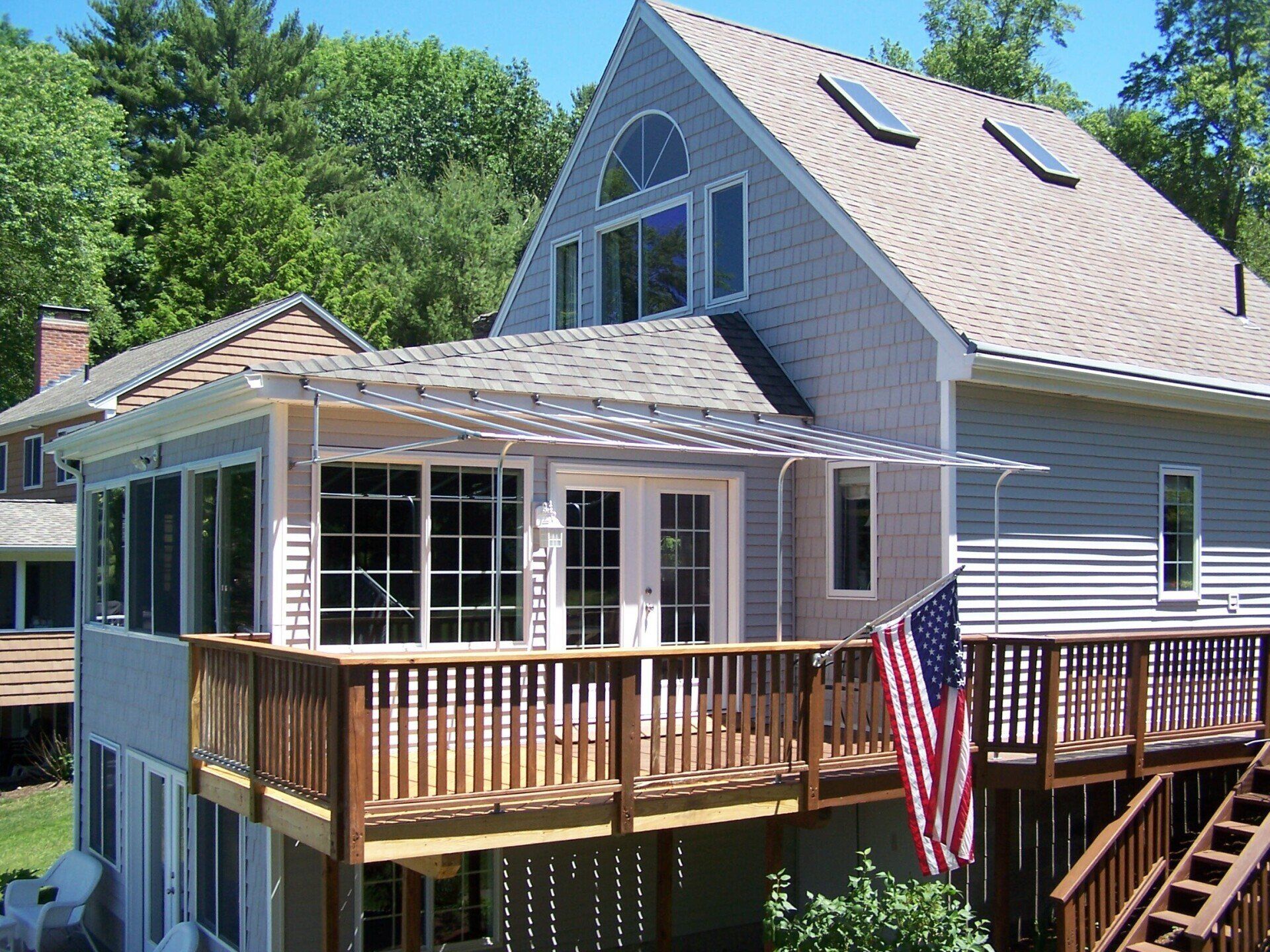 A house with a large deck and an american flag on it