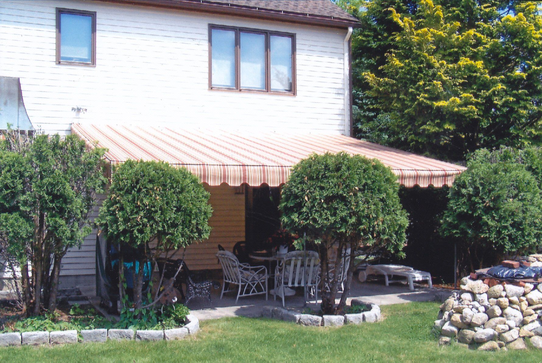 A house with a striped awning on the porch