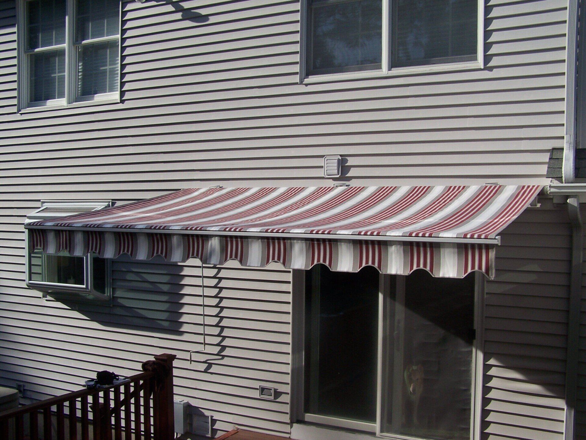 A red and white striped awning is on the side of a house