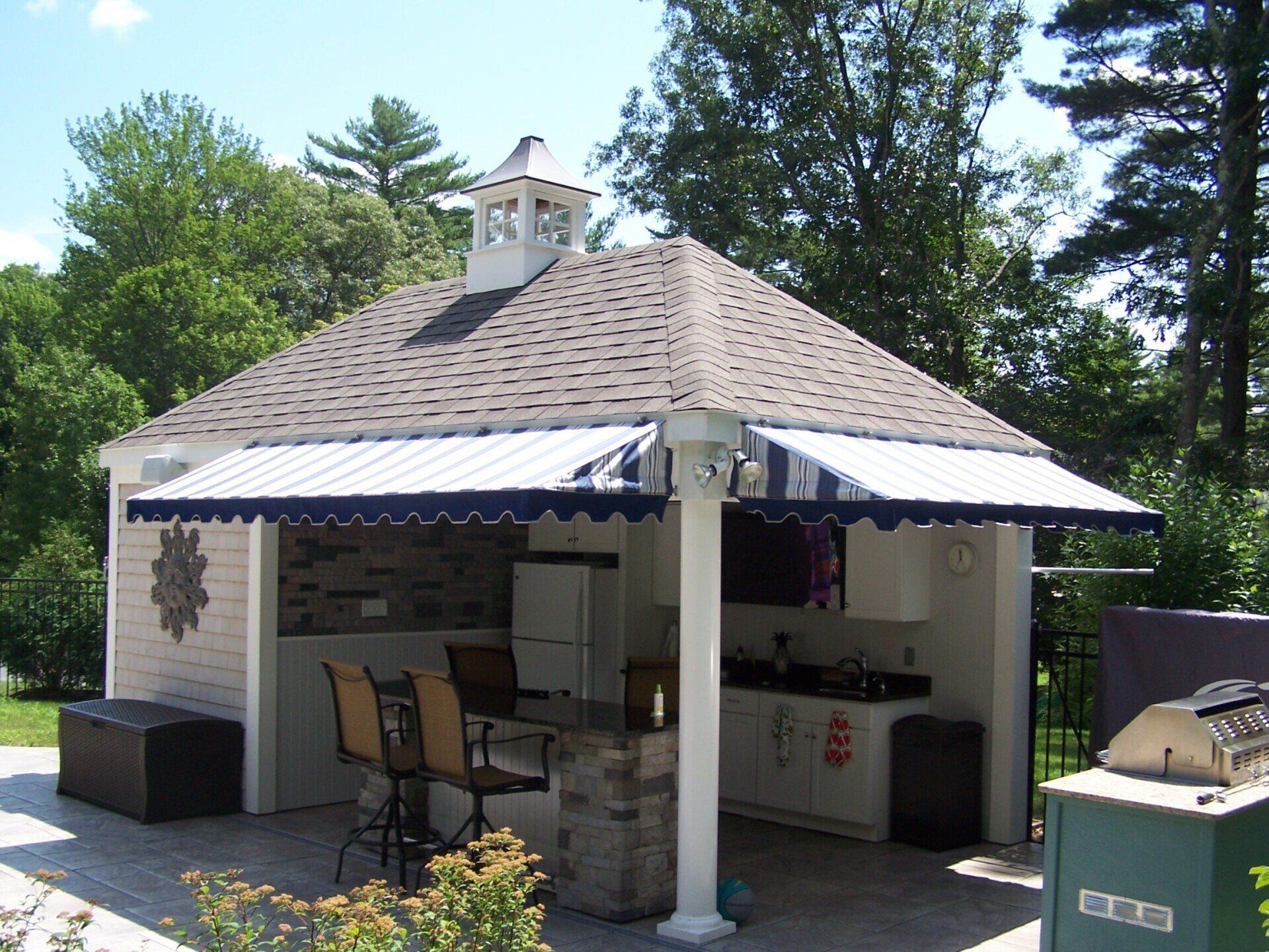 A pavilion with a blue and white awning over it