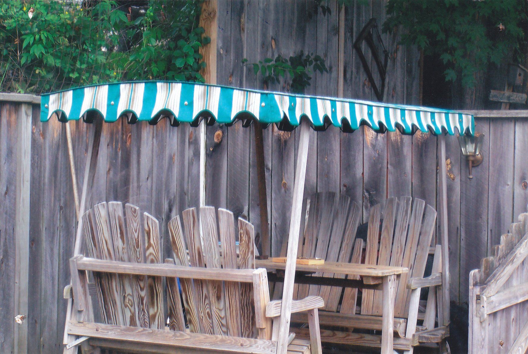 A wooden bench with a green and white awning over it