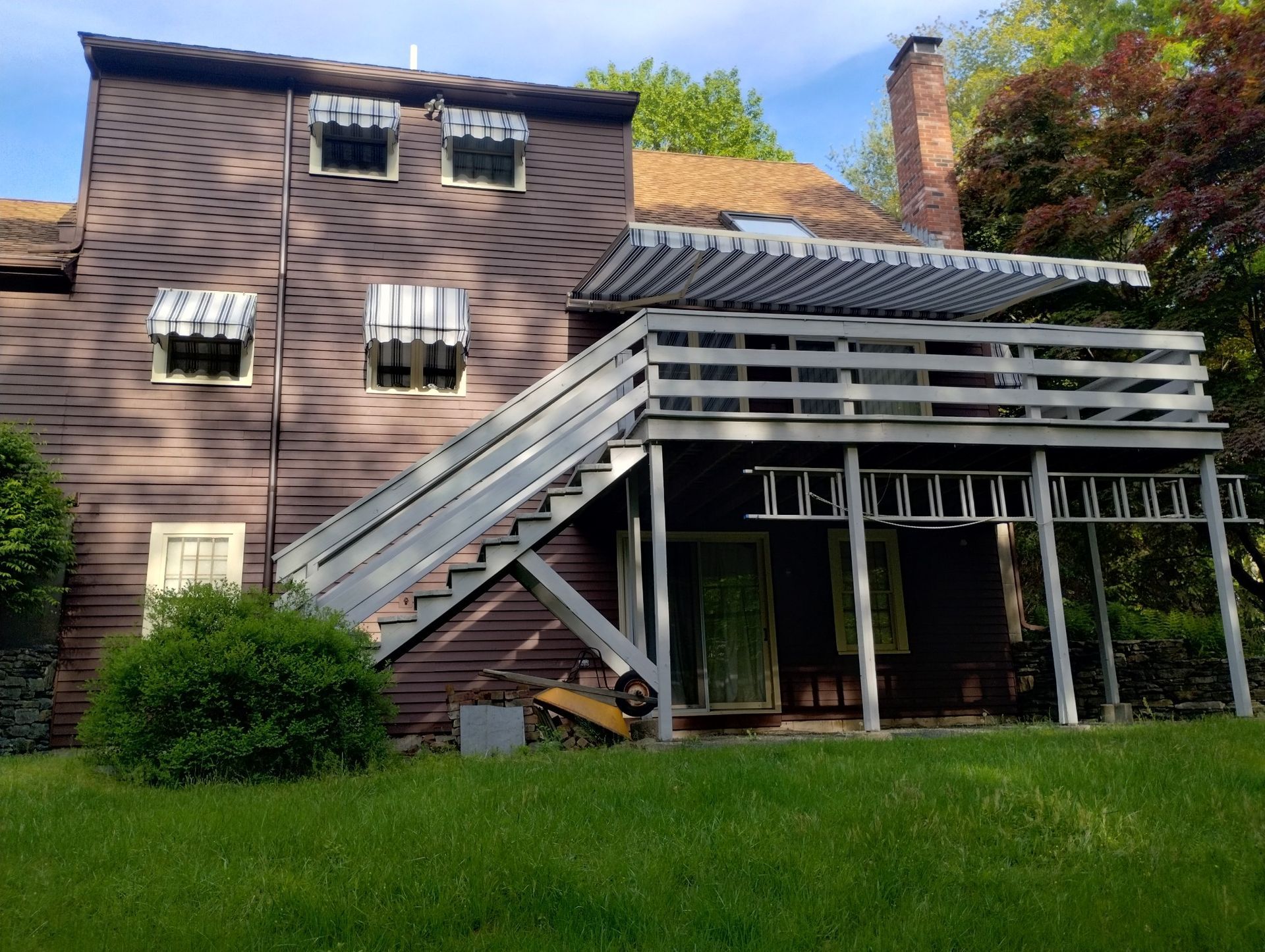 The back of a house with stairs leading up to the deck