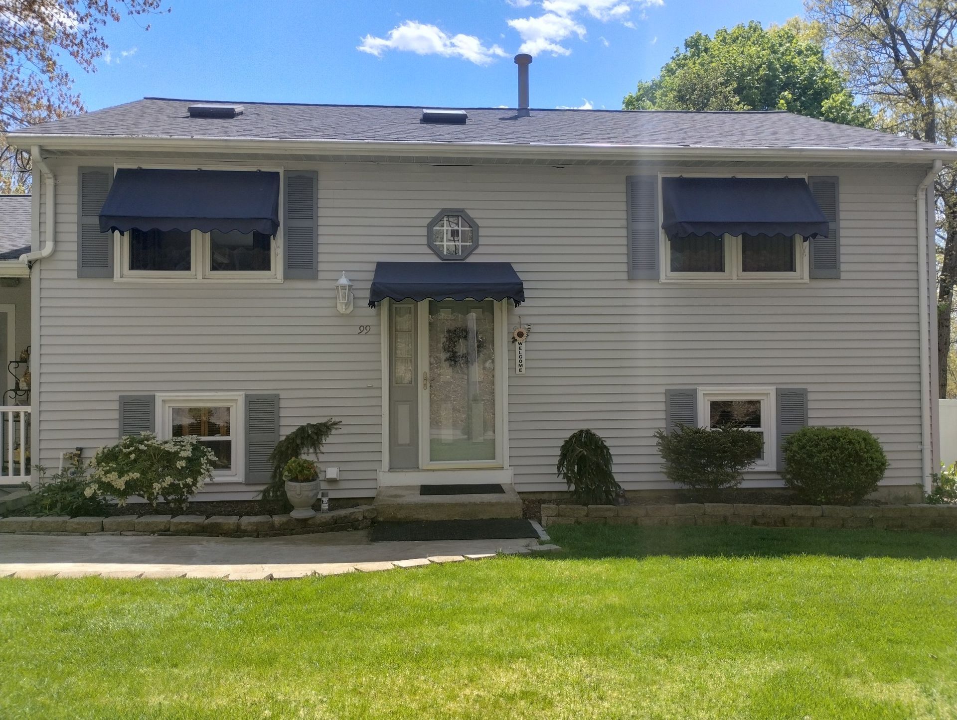 A house with a blue awning on the front door