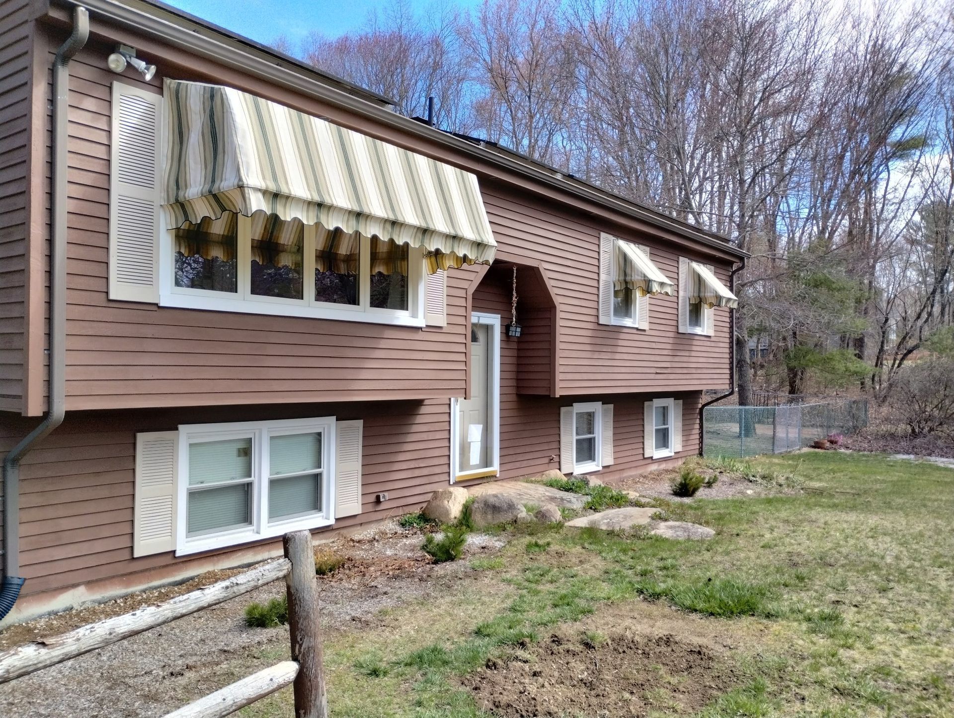 A house with a striped awning on the front of it
