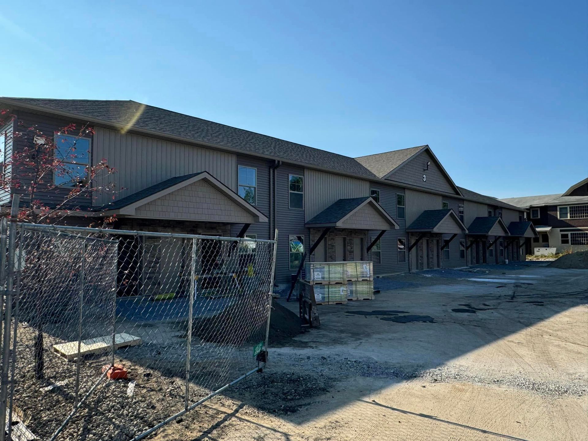 A building under construction with a chain link fence in front of it