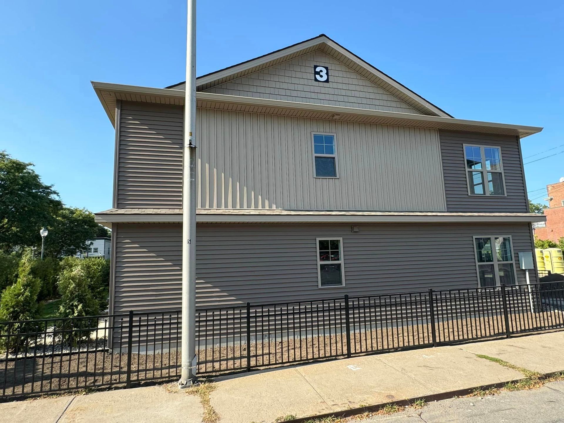A large property with a fence around it and a number 3 sign near the roof