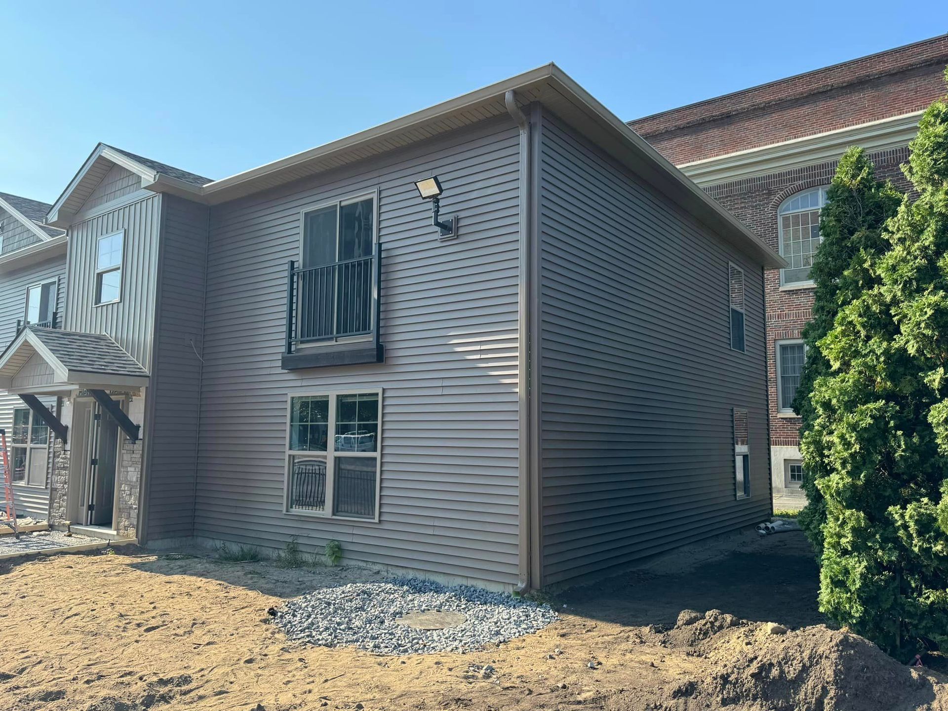 A property with a lot of windows with newly installed gutters and downspouts